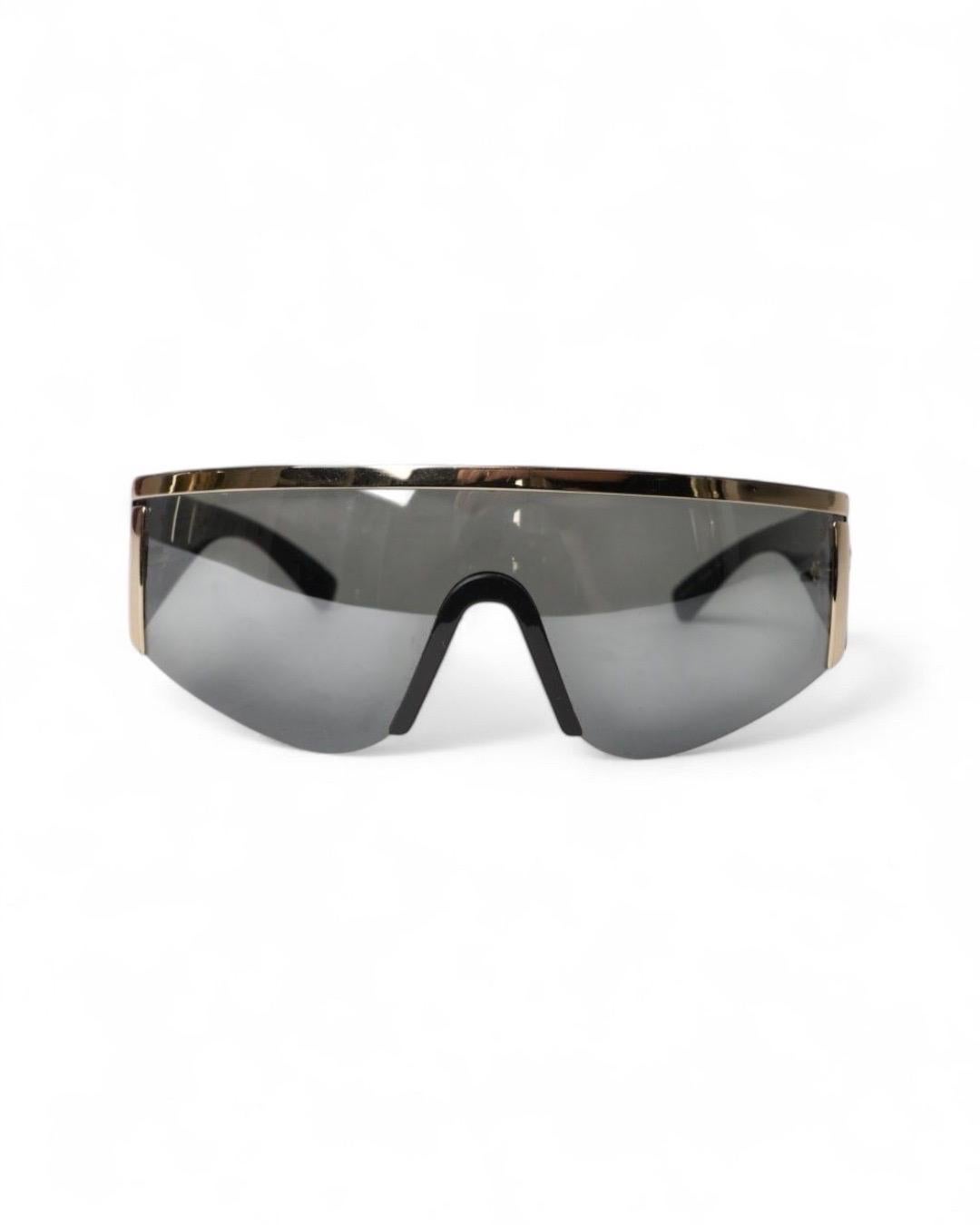 Occhiali Da Sole firmati Gianni Versace Vintage, modello Visiera, realizzate in acetato con inserti dorati. Arricchite dal classico logo medusa sul lato. L'articolo si presenta in ottime condizioni.
-----
Gianni Versace Vintage Visor-Sonnenbrille