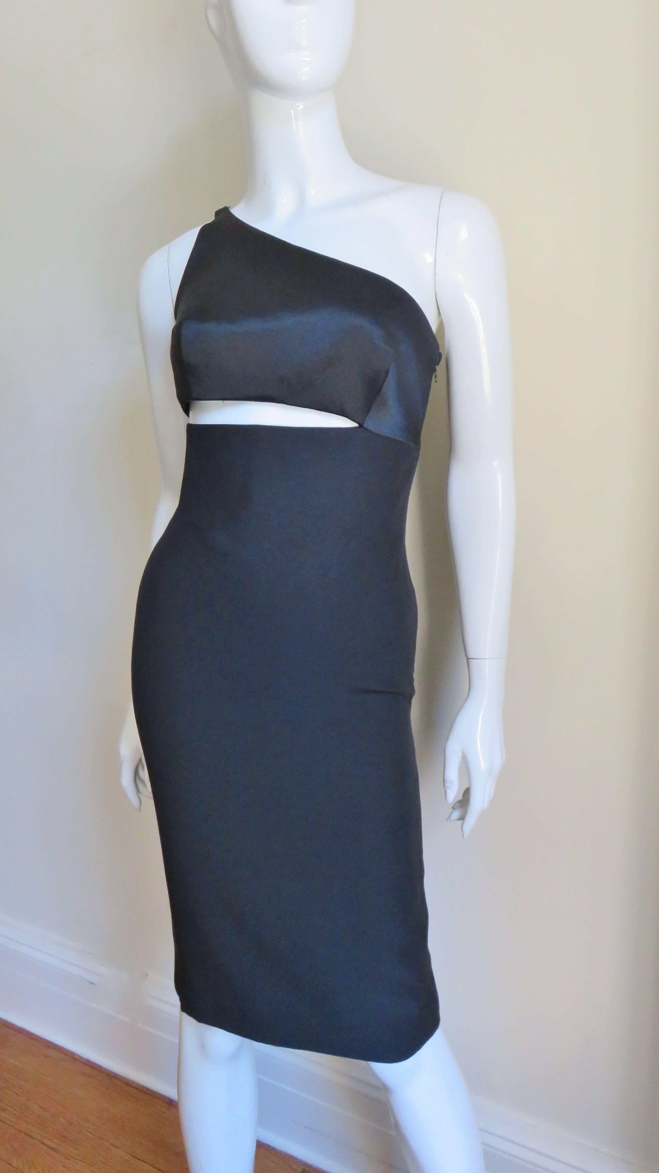 A fabulous black silk dress from Gianni Versace.  It is comprised of a one shoulder bodice attached by one side to the skirt portion leaving a wedge of exposed skin between the two.  It is fully lined in silk, closes with a side zipper and has a
