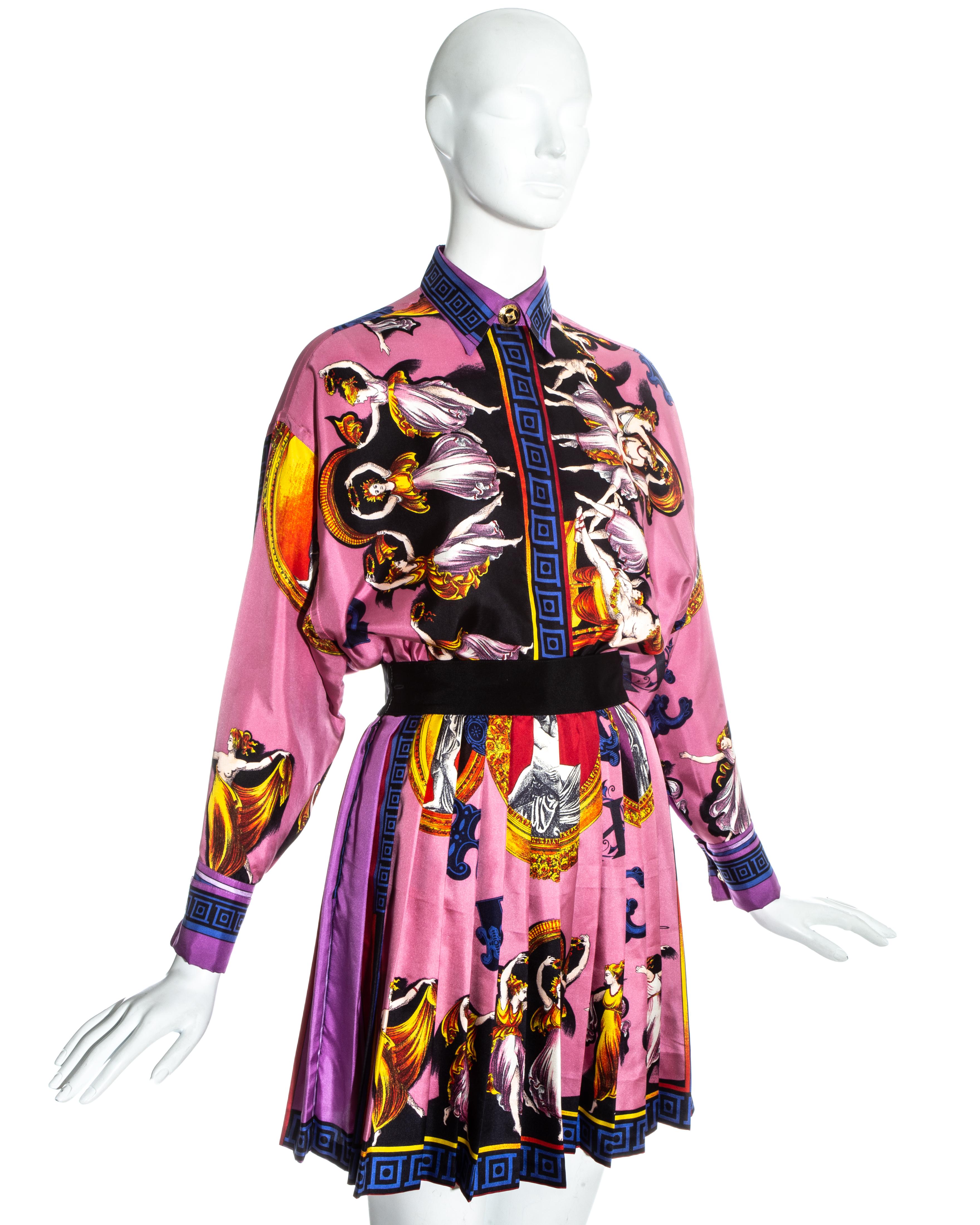 Gianni Versace pink silk skirt suit with a colourful neoclassical print. Loose cut blouse with large gold buttons on collar and cuffs. High waisted pleated skirt with black waistband. 

Fall-Winter 1991