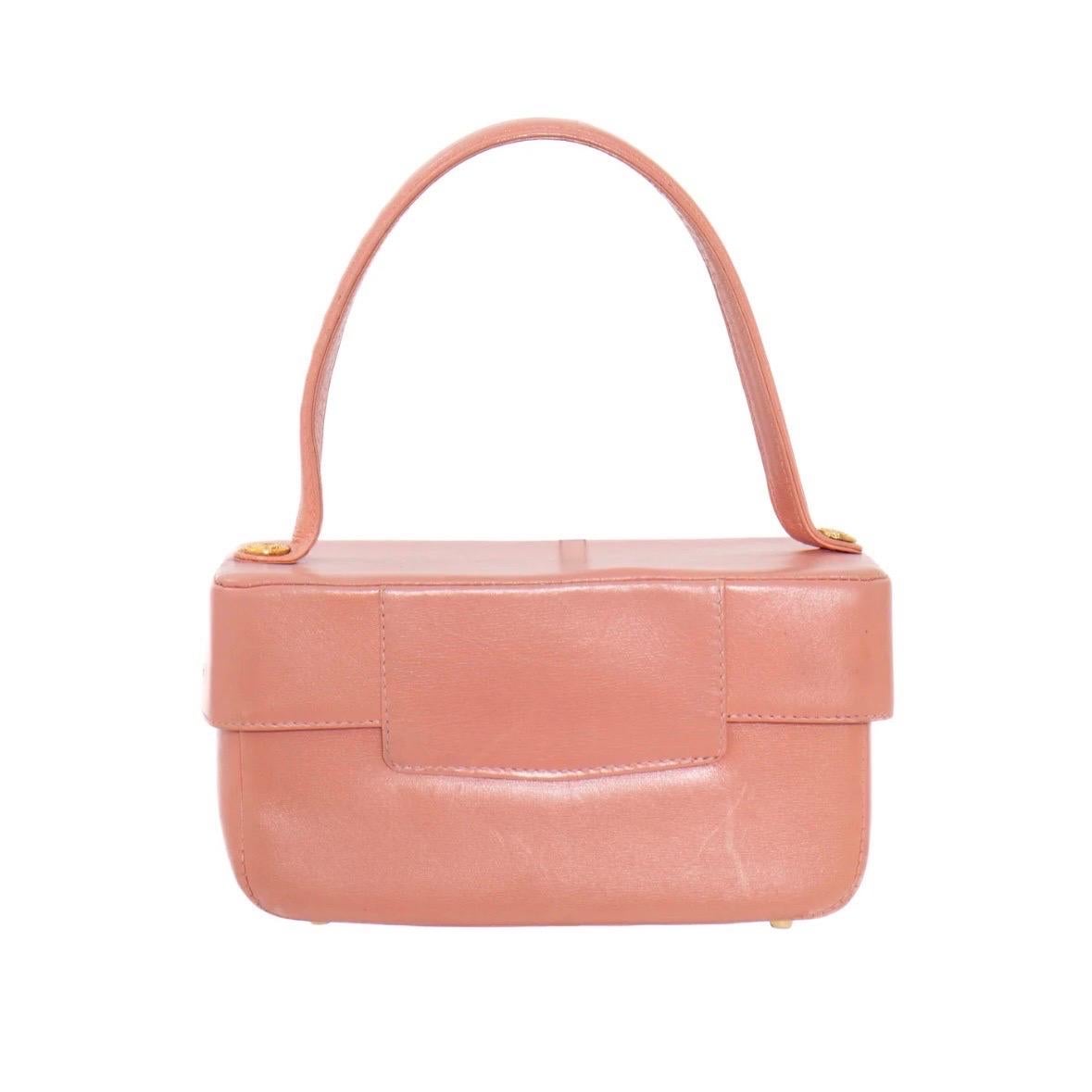 Top handle bag by Gianni Versace
Circa 1990's
Box shape
Pink leather
Gold-tone hardware
Lock front closure 
Leather top handle with Medusa head buttons
One slip pocket
Five base feet 
Lock not included
Condition: good; some creasing and scuffs.