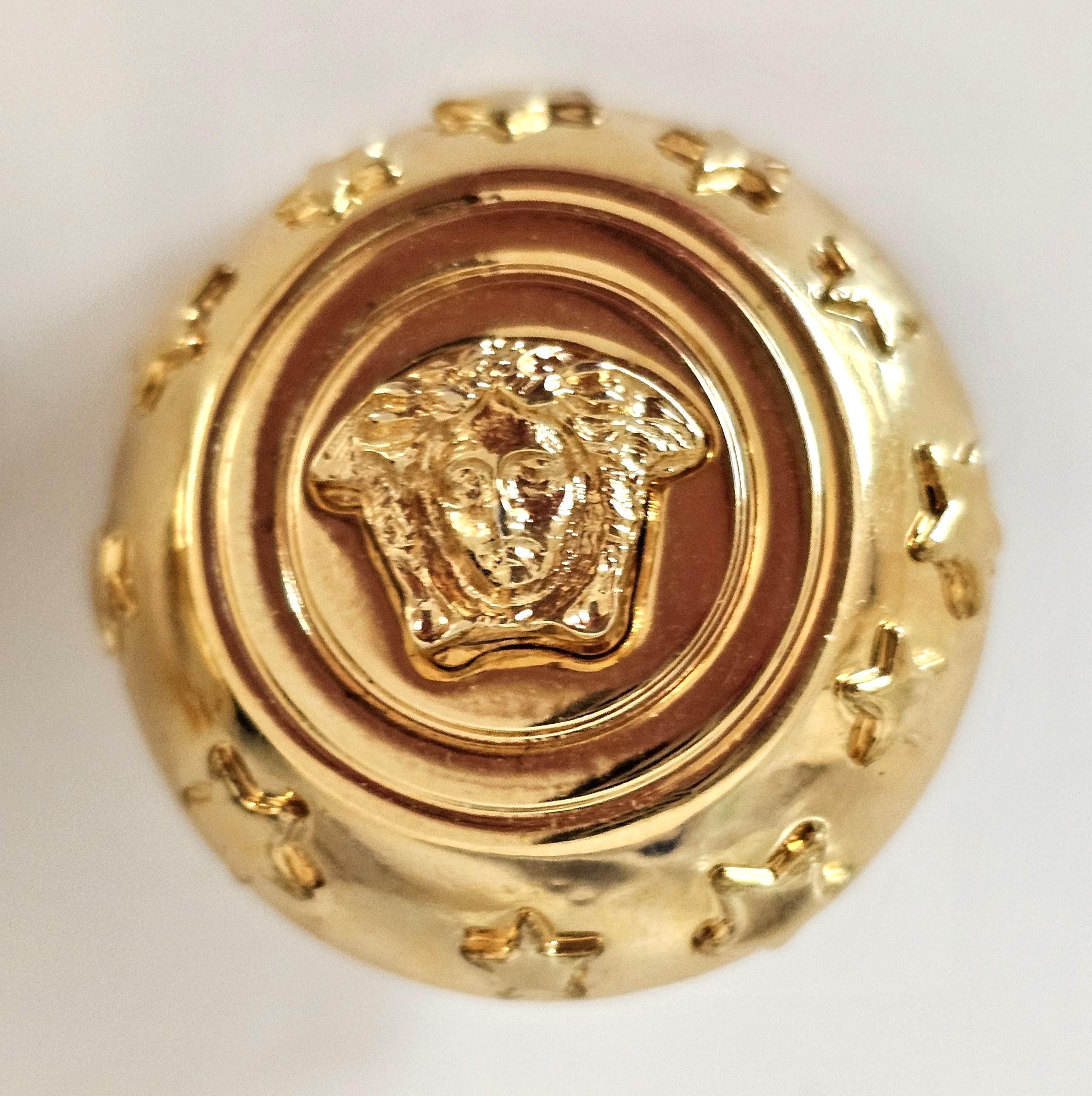 Los auténticos pendientes de clip Gianni Versace Profumi vintage son piezas icónicas de los años 80, célebres por su atrevido diseño y su emblemática Medusa. Firmado Gianni Versace Hecho en Italia. Estos pendientes suelen estar fabricados en metal