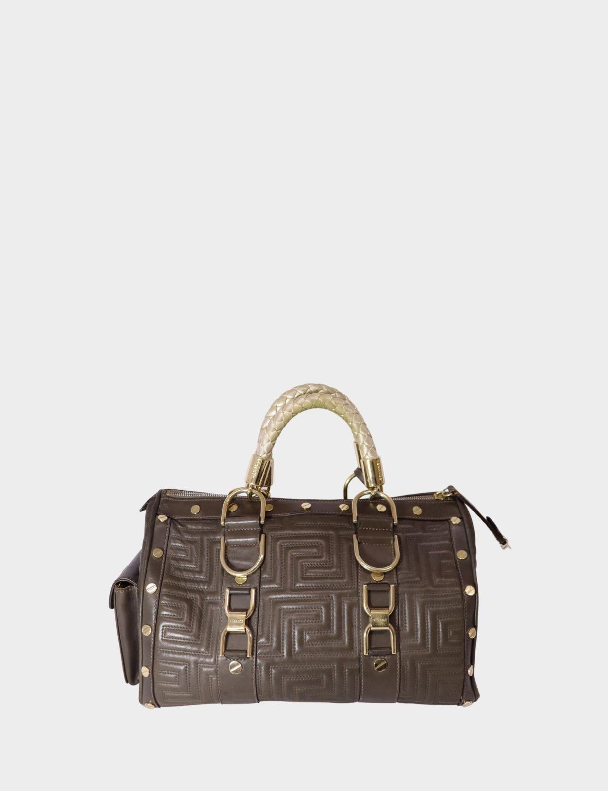 Make a luxurious statement with this Gianni Versace brown quilted leather satchel, a timeless piece that embodies bold Italian craftsmanship. Featuring an intricate geometric quilted pattern, this structured bag is adorned with signature gold-tone