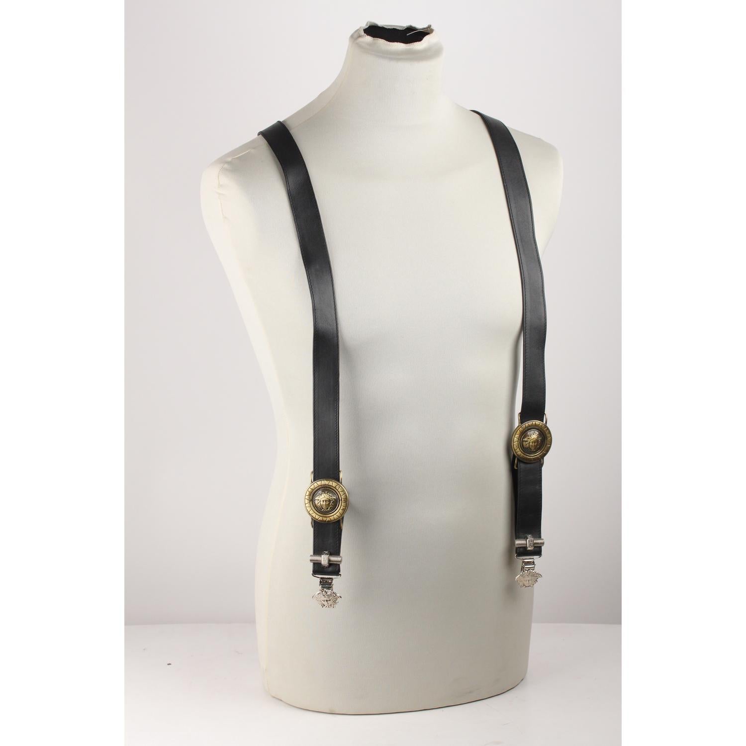 Rare vintage Gianni Versace black leather adjustable suspenders from the 1990s. They feature  decorative silver metal Medusa heads at the end of each clip. Medusa gold-tones hardware on the front and Medusa silver-tone hardware on the back. Medusa