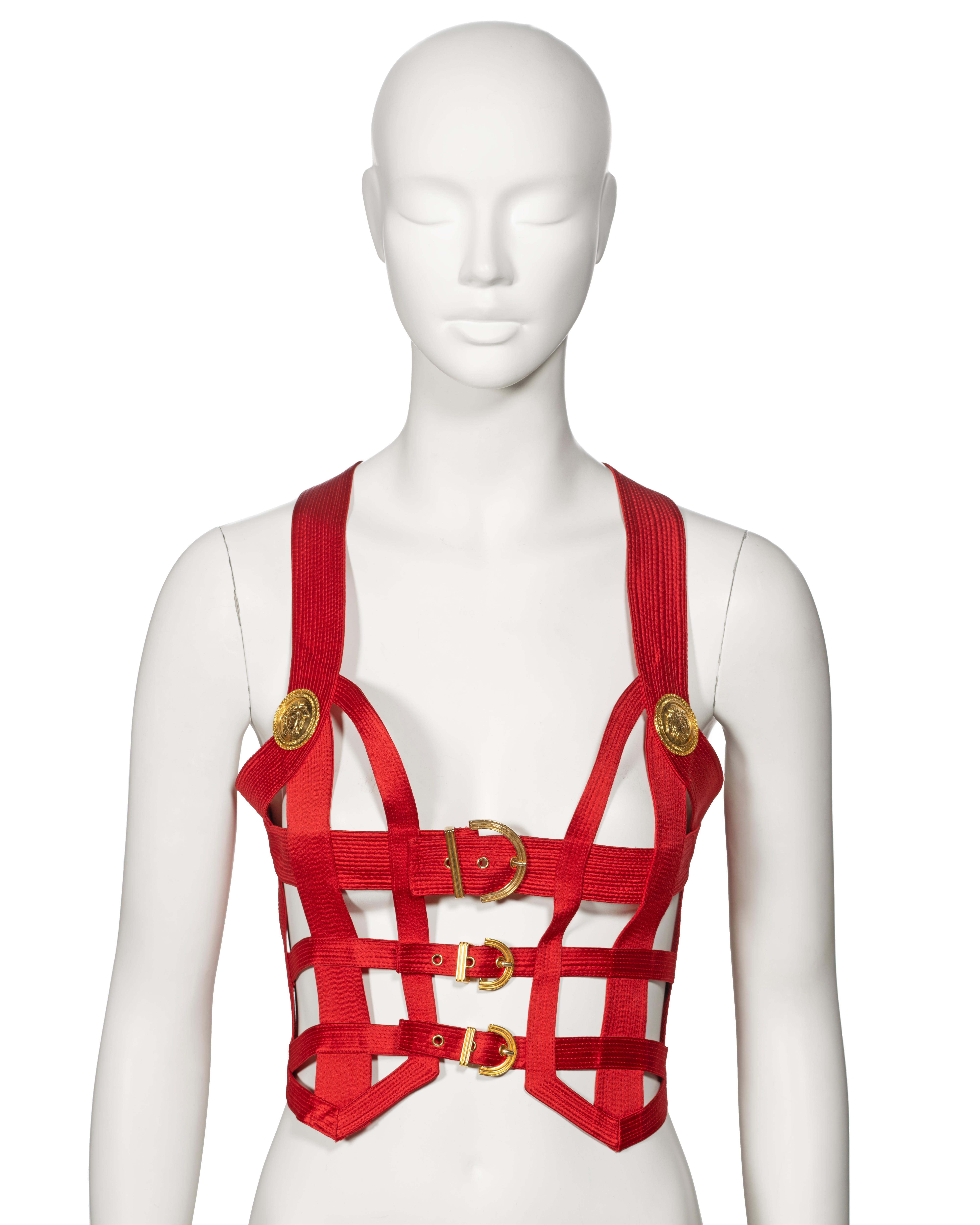 ▪ Archival Gianni Versace Bondage Corset 
▪ Creative Director: Gianni Versace
▪ Fall-Winter 1992
▪ Sold by One of a Kind Archive
▪ Museum Grade
▪ Constructed from multiple red channel stitch silk bands forming a caged design
▪ Gold tone Medusa