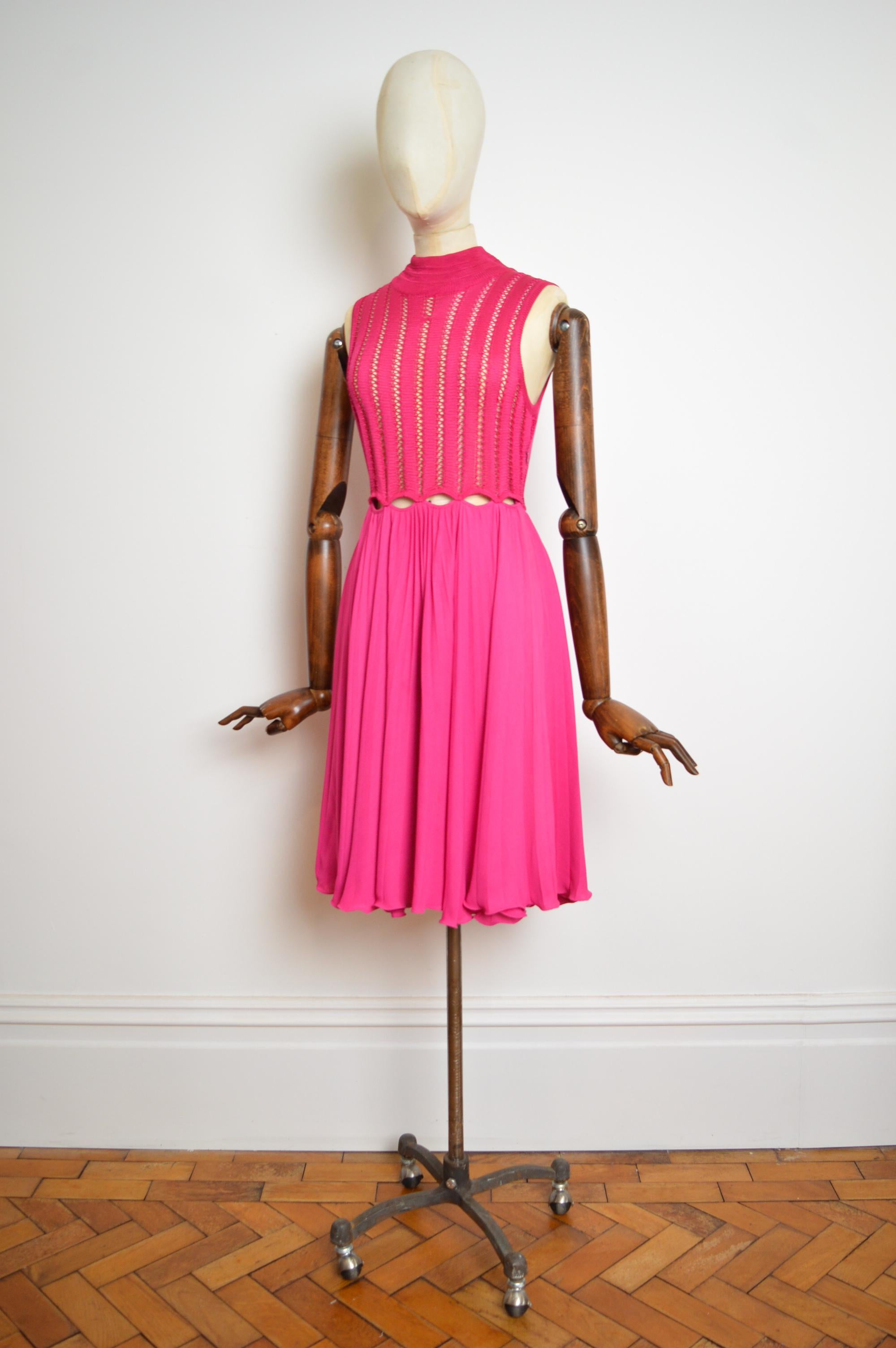 Un bellissimo e vivace abito da passerella di Gianni Versace (circa 1993) in un crochet fucsia con dettagli tagliati in vita e una gonna plissettata al ginocchio.

MADE IN ITALY.

Le misure sono indicate in pollici;
Da fossa a fossa; 16