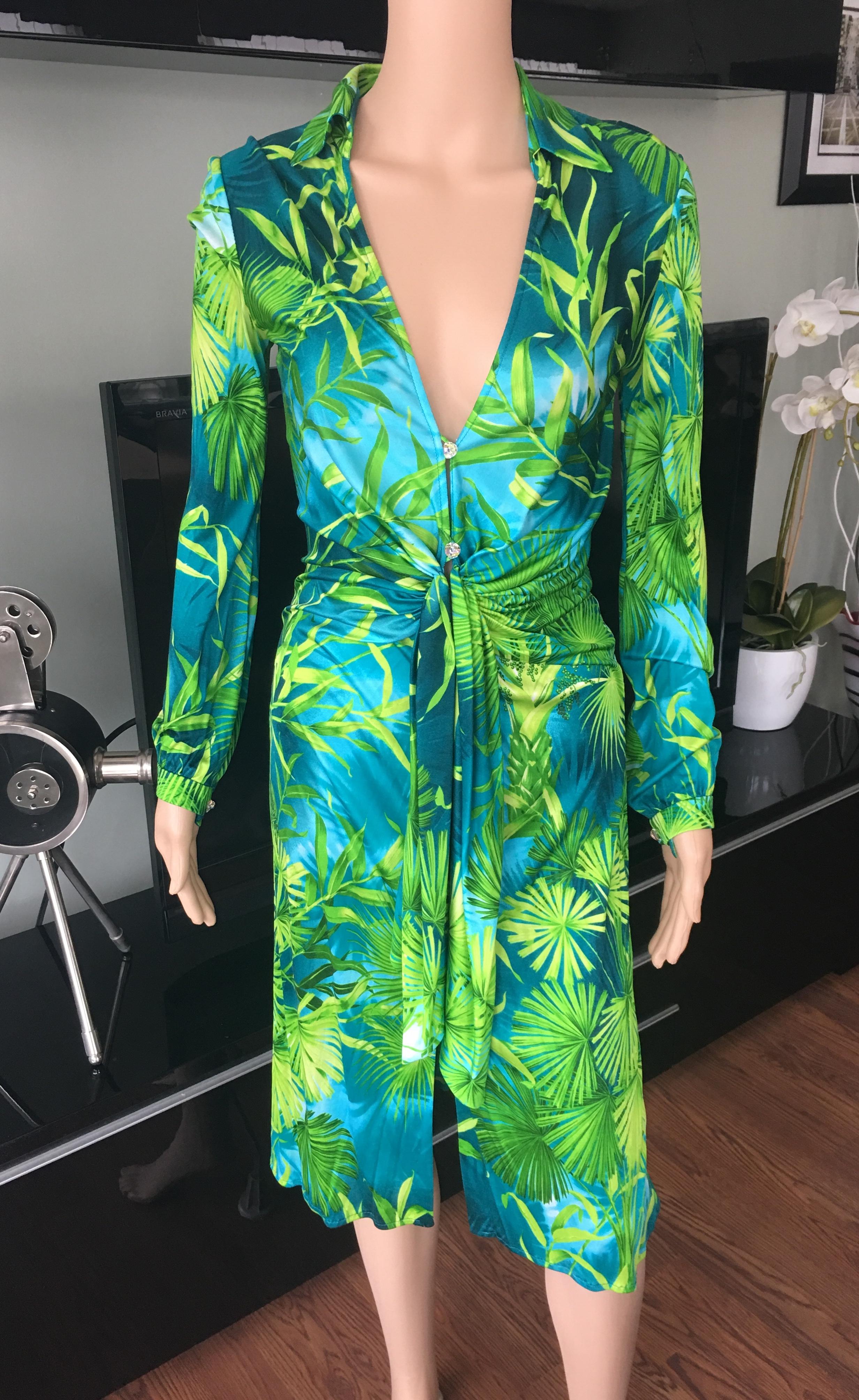Look 1 from the Spring 2000 Collection. Green tropical palm print silk low cut dress from Gianni Versace Vintage featuring Swarovski crystal buttons, long sleeves, a plunged neckline style and a knee length. Size IT 38. Excellent Condition. Made in