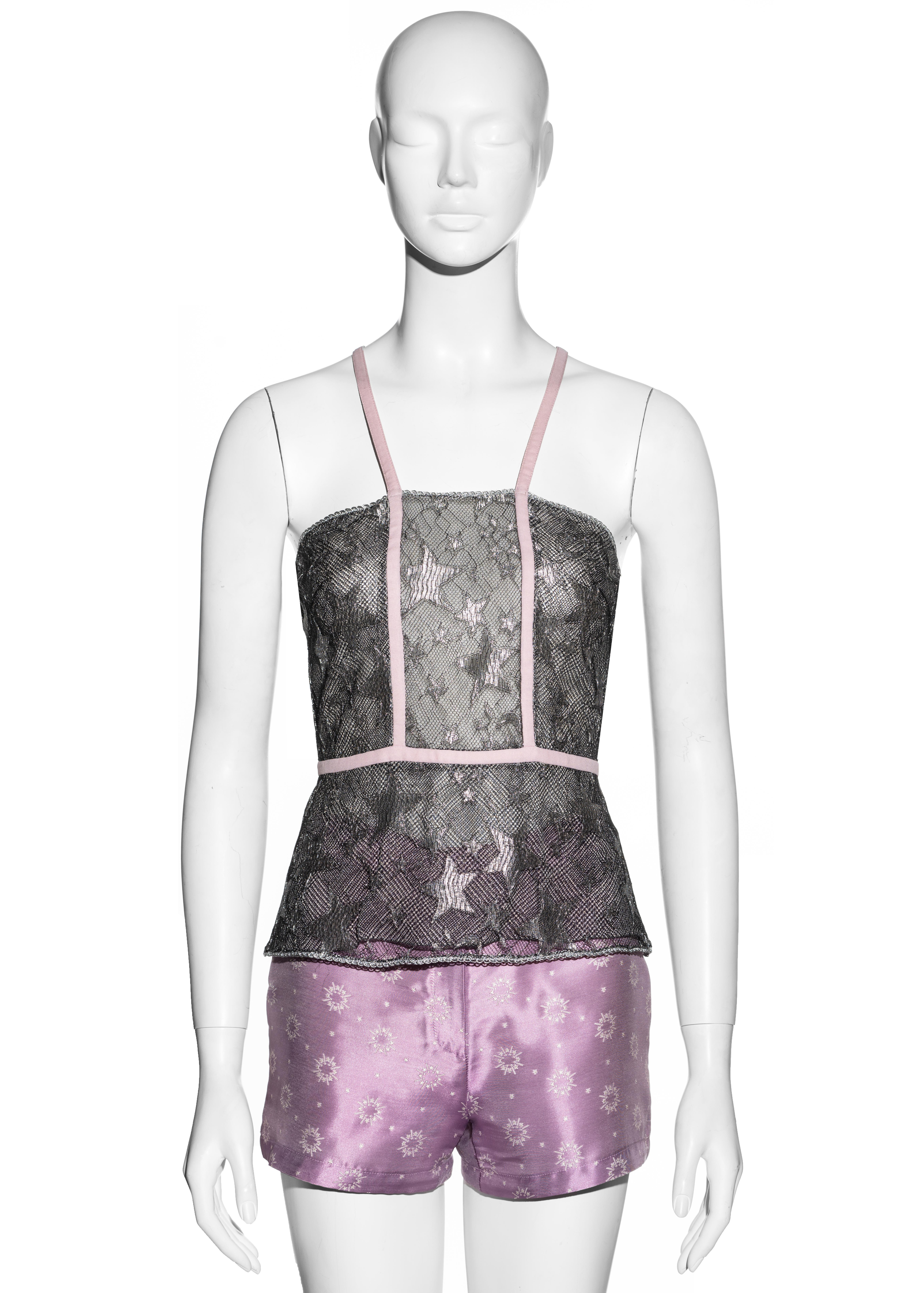 ▪ Gianni Versace wrap vest and hot pants set
▪ Metallic silver net lace with star print 
▪ Pink criss-cross shoulder straps 
▪ Princes of Wales check underlay 
▪ Pink satin jacquard hot pants 
▪ IT 38 - FR 34 - UK 6 - US 2
▪ Spring-Summer 1998