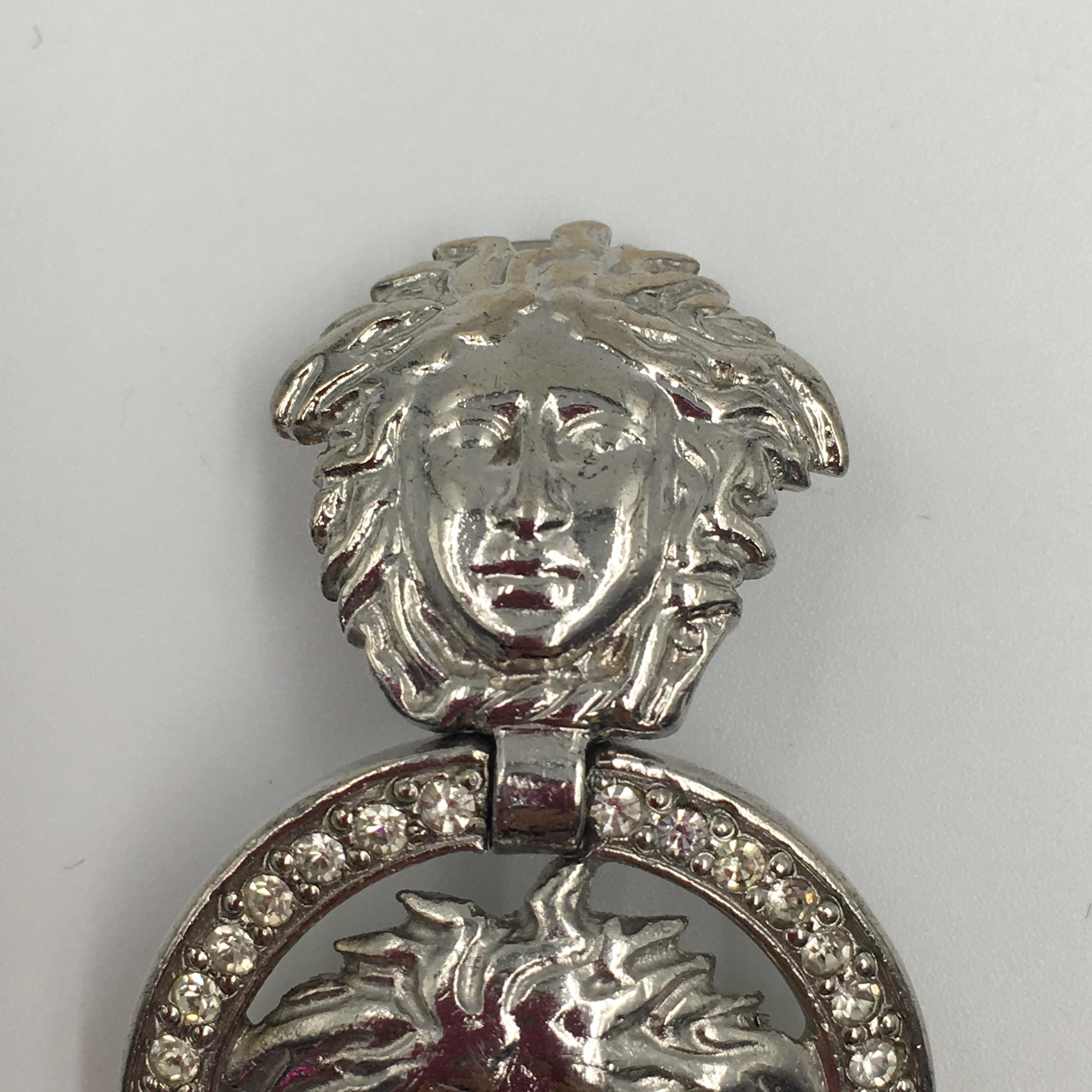 Gianni Versace Silver Tone Medusa Clip On Drop Earrings. Medusa head clip on with Medusa head surrounded by a circle of rhinestones. Gianni Versace stamped on backside of each earring. 

Good vintage condition. 

Measurements are as follows:
Height
