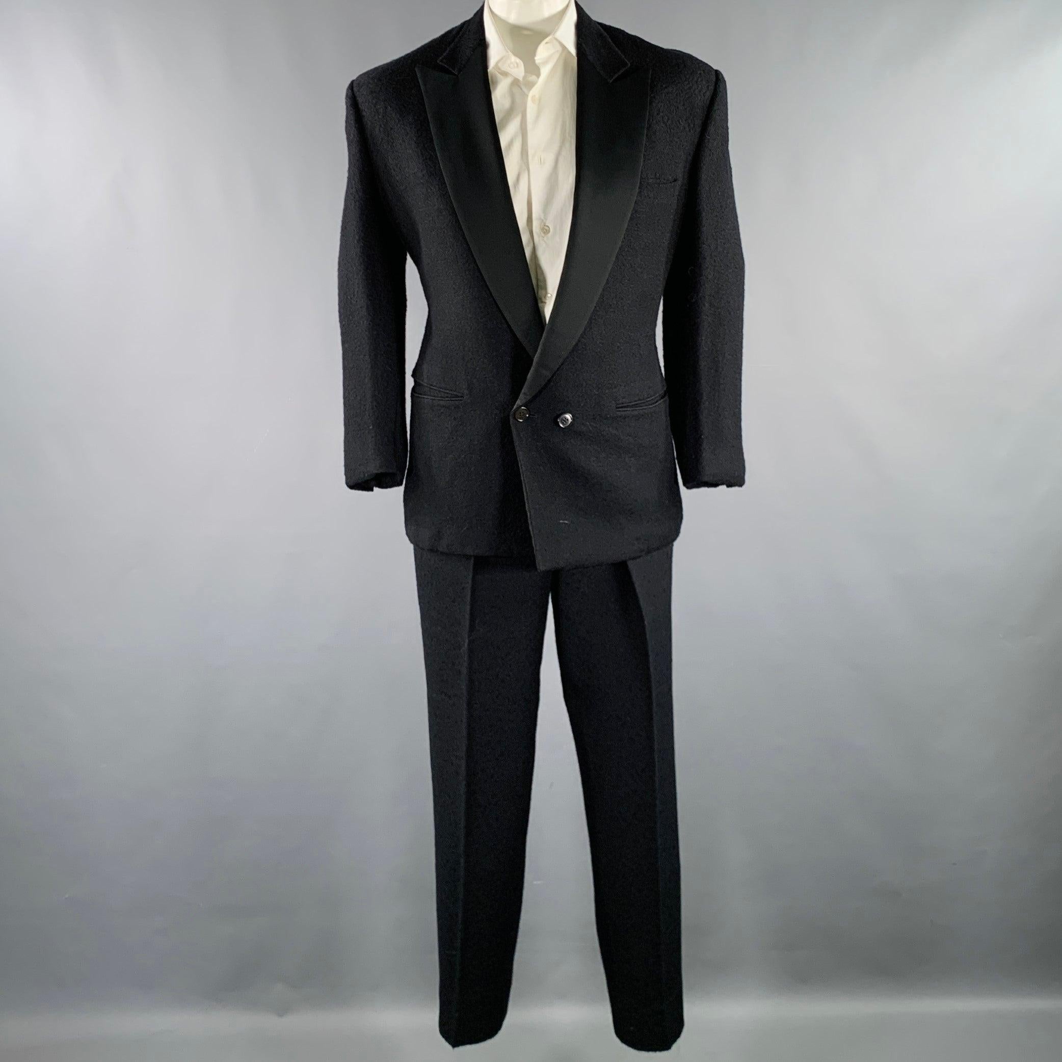 Smoking vintage GIANNI VERSACE
dans une soie de laine bicolore noire avec une demi-doublure et comprend un manteau de sport à double boutonnage avec un revers à cran et un pantalon à plis assorti. Fabriqué en Italie. Très bon état Vintage. Signes