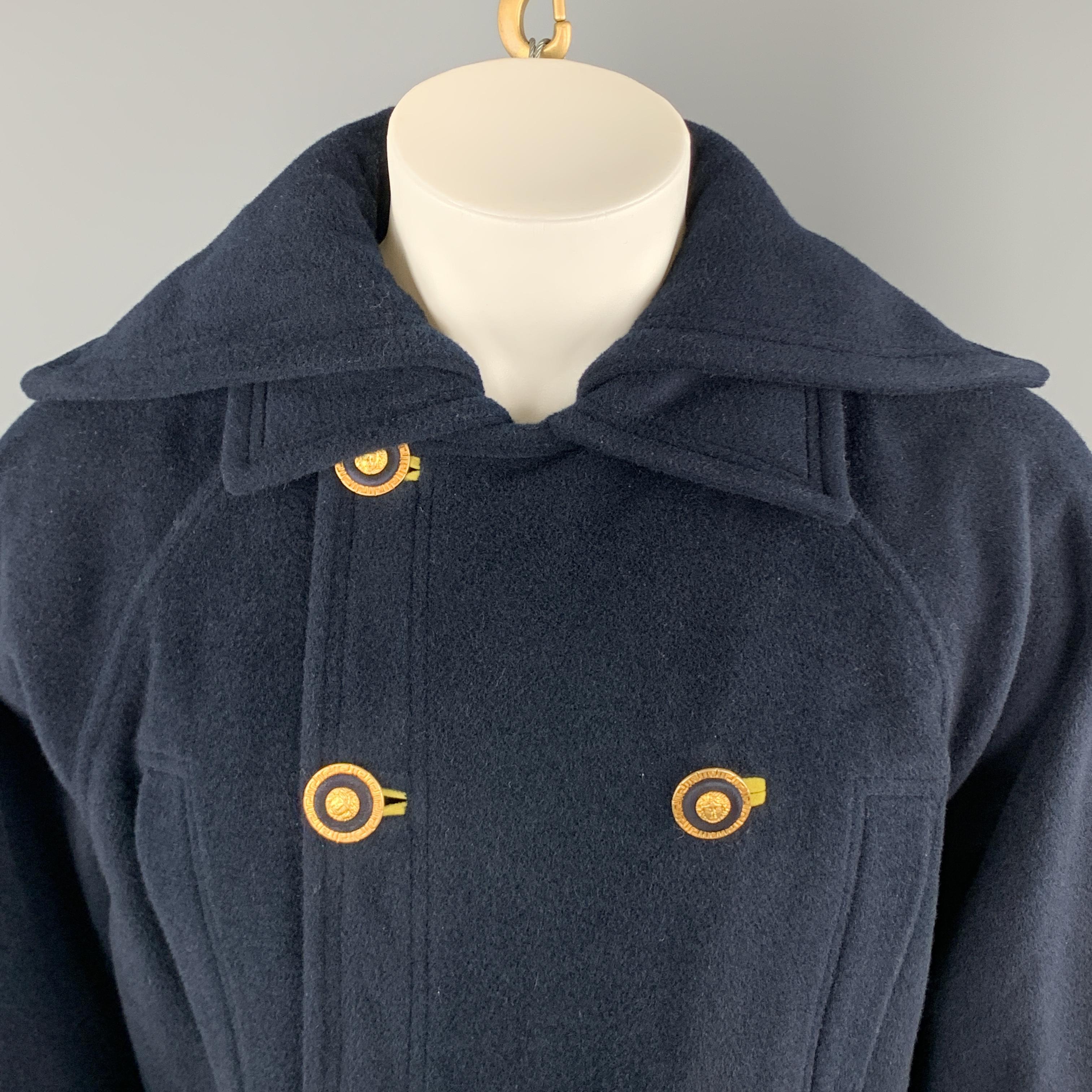 Vintage GIANNI VERSACE cropped pea coat comes in heavy navy blue wool cashmere blend felt with a double pointed collar, raglan sleeves with functional button cuffs, slit pockets, flap pockets, and double breasted front with gold tone Medusa head