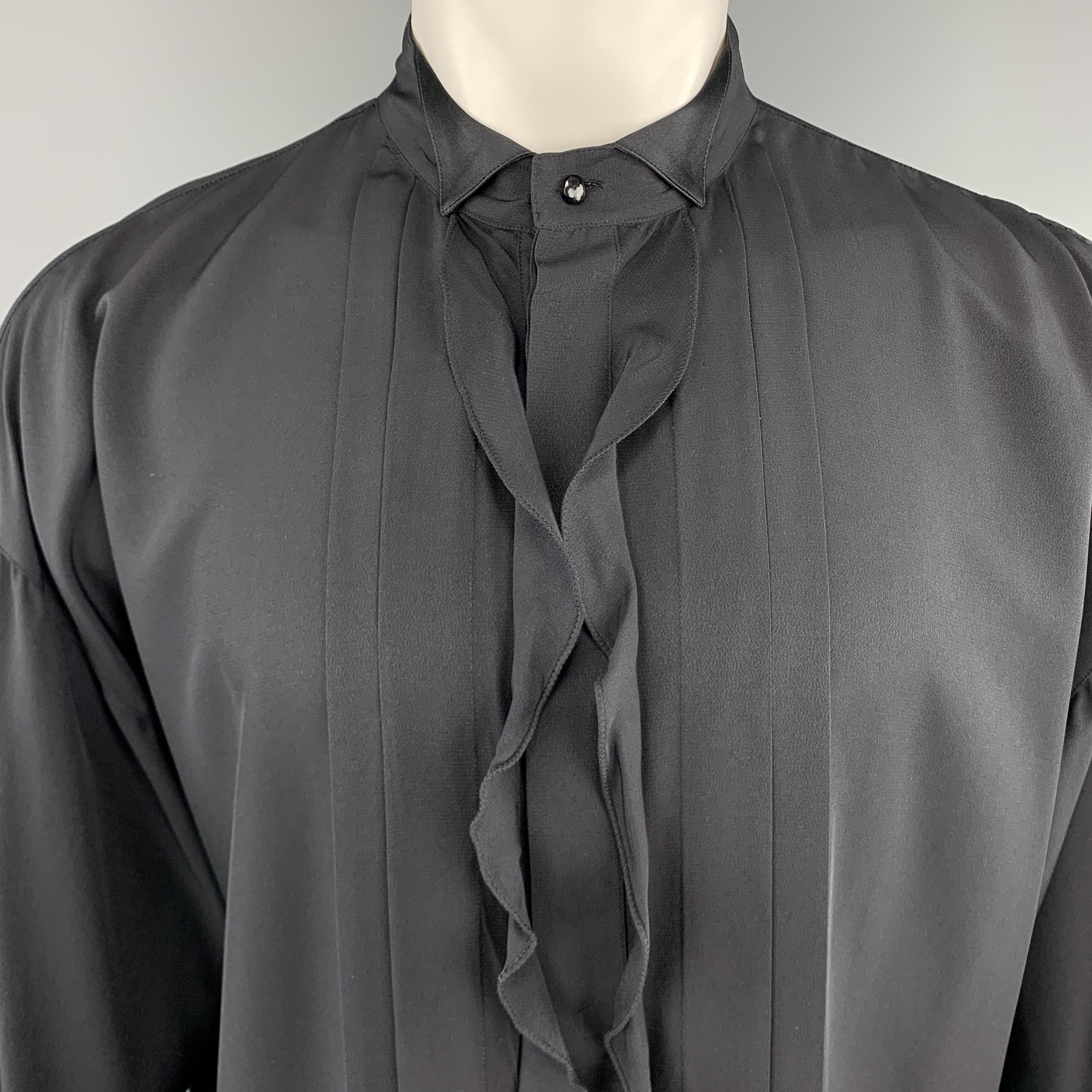 Vintage GIANNI VERSACE tuxedo shirt comes in black silk crepe with an oversized silhouette, wing tip collar, and hidden placket button front with ruffled trim and pleated detail. Made in Italy.

Very Good Pre-Owned Condition.
Marked: IT