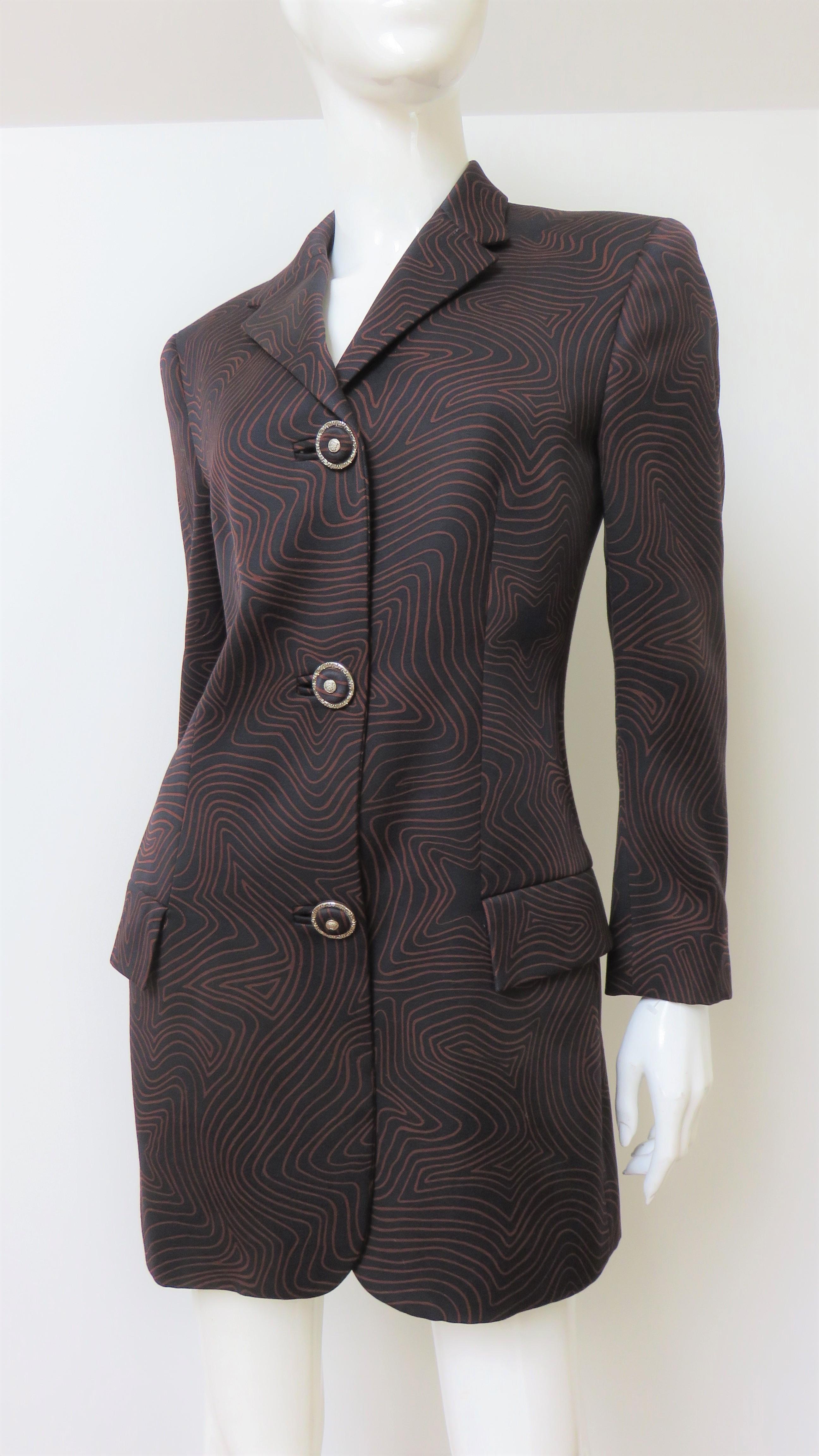 A fabulous black silk jacket with a brown line star pattern from Gianni Versace Couture.  It is a long blazer style jacket with incredible elaborate matching buttons and bound buttonholes closing the front and on the cuffs.  It has 2 front flap