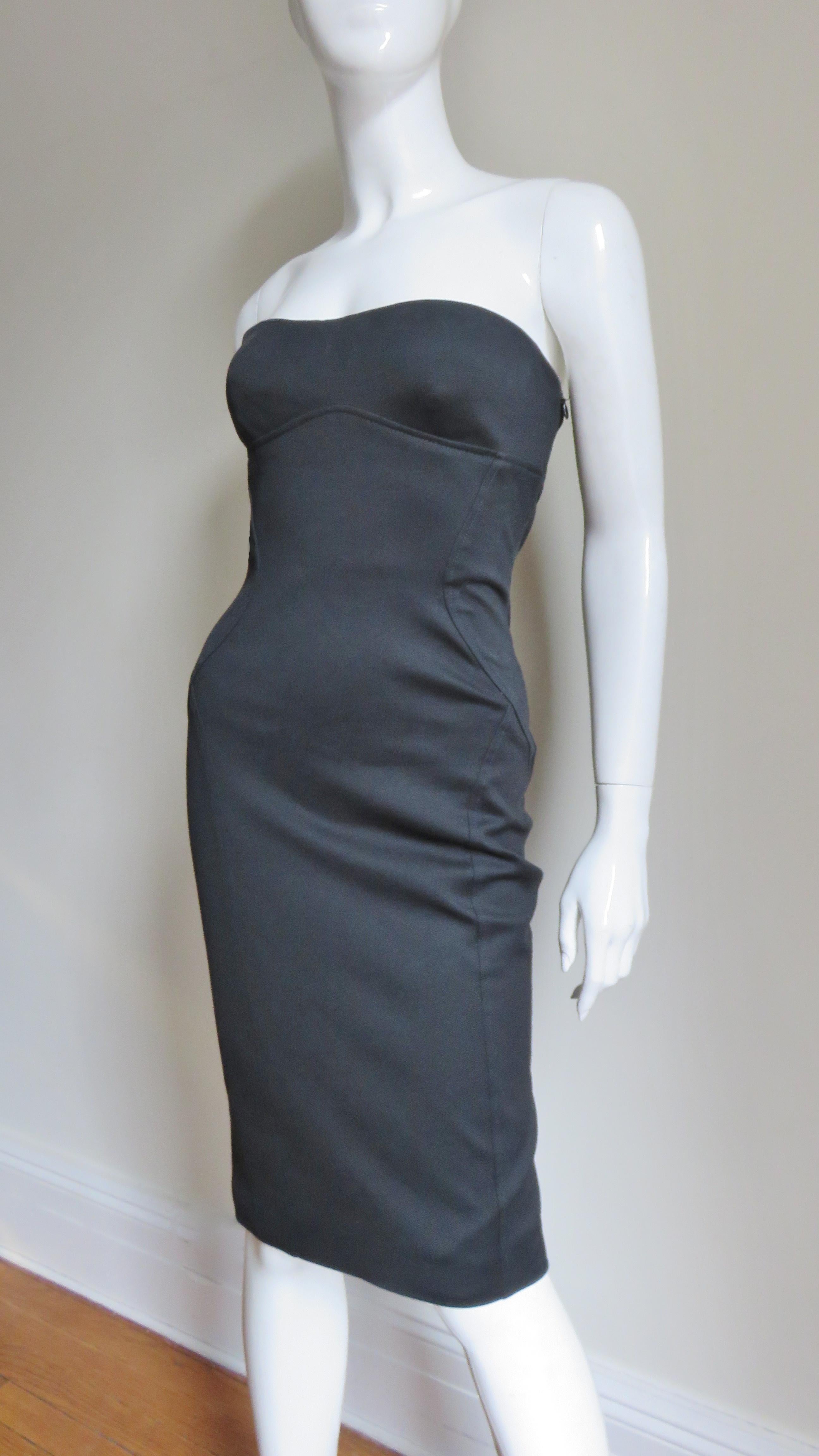 A fabulous black silk strapless dress from Gianni Versace Couture.  It is fitted with flattering seaming and center back lacing, functional on the skirt portion with fine leather laces with Medusa head metal ends and elaborate grommets.  There is an