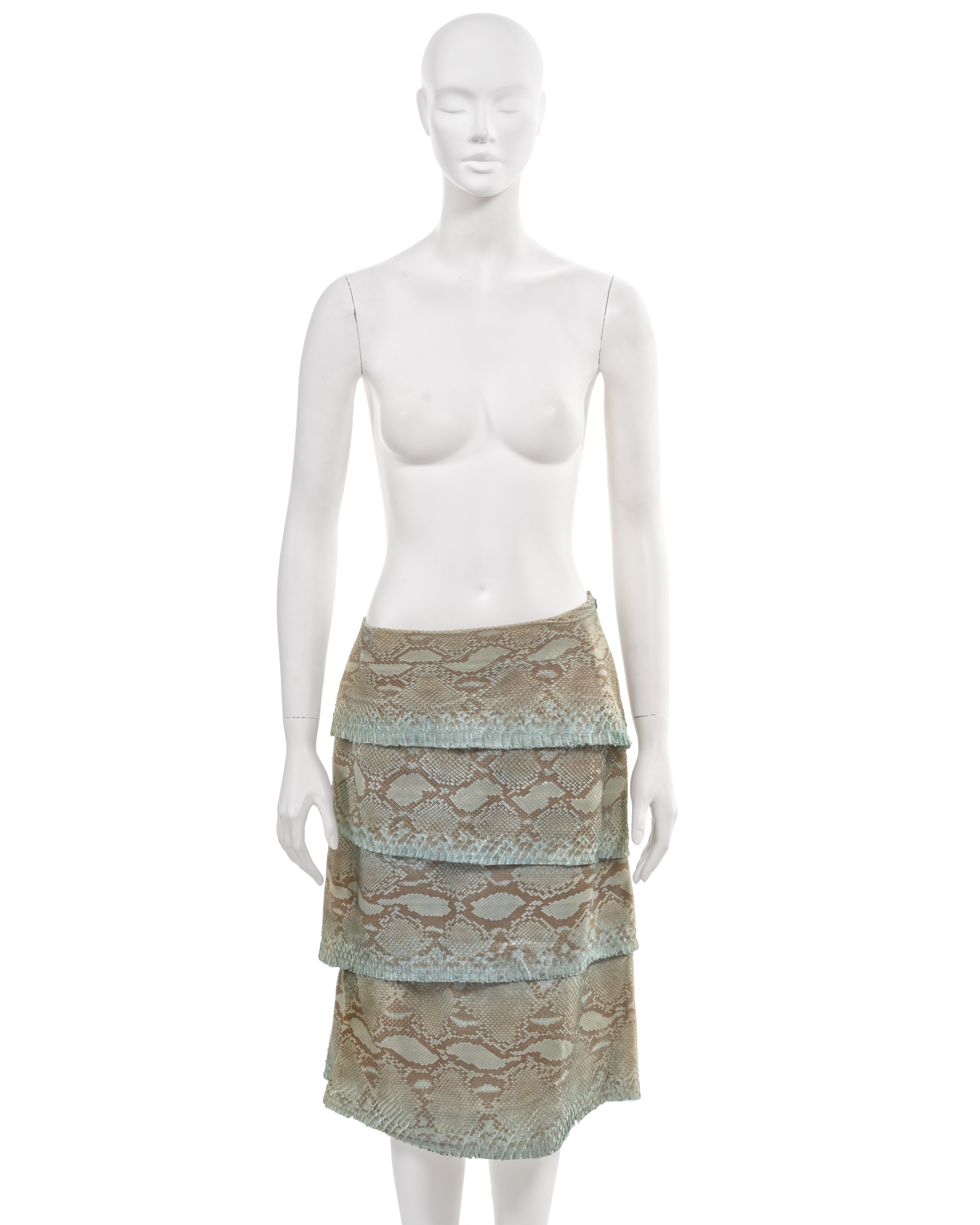 ▪ Gianni Versace knee-length leather skirt 
▪ Creative Director: Donatella Versace
▪ Fall-Winter 1999
▪ Sold by One of a Kind Archive 
▪ Expertly crafted from four tiers of dyed turquoise python skins
▪ Asymmetric waist and hemline 
▪ Hanging drape