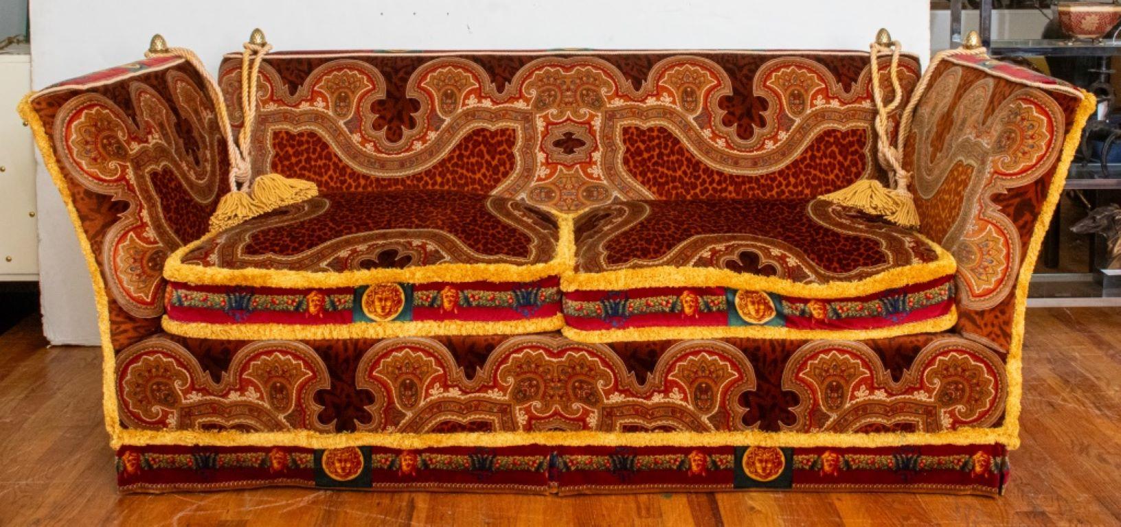 Gianni Versace (Italian, 1946-1997) upholstered suite comprising a Knole sofa with two loose seat cushions, two Knole armchairs with loose seat cushions, two ottomans with removable fringed cushions, with two small fringed rectangular pillows, each