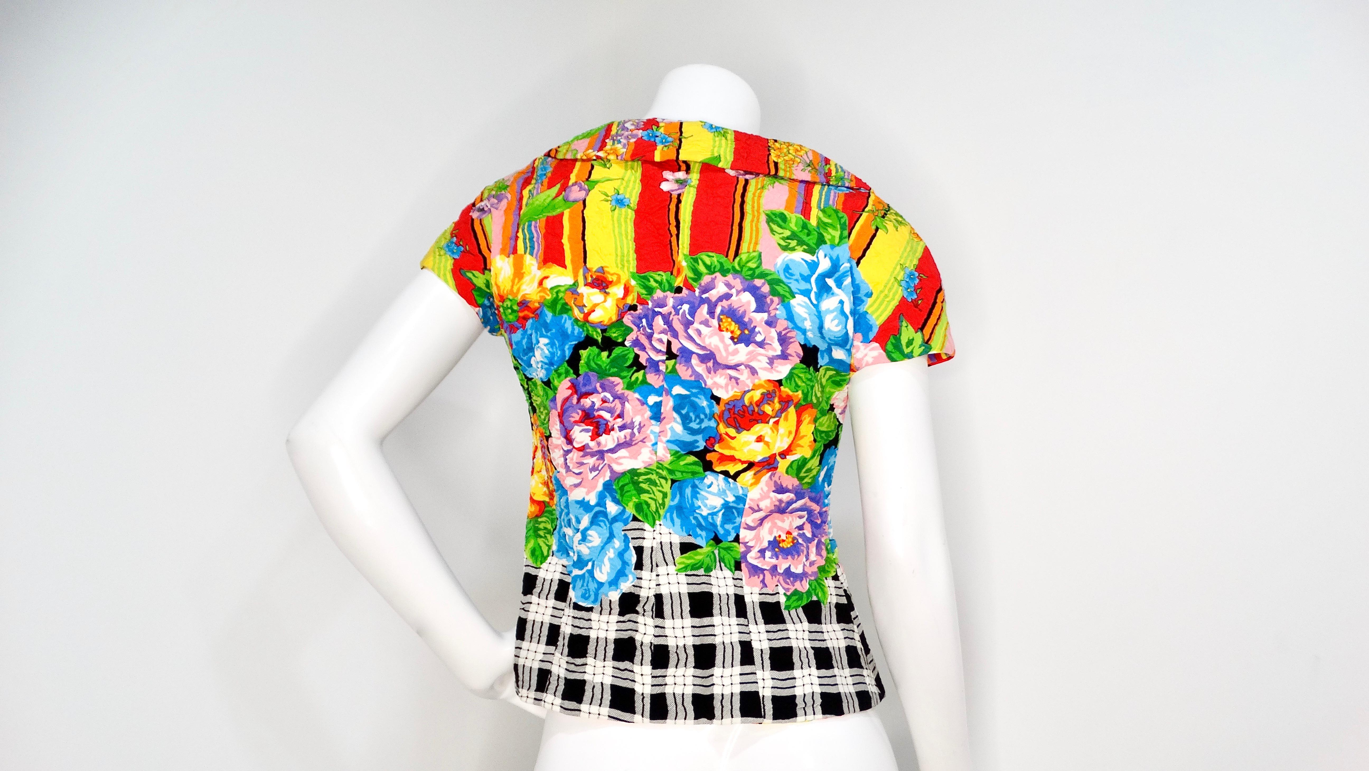 The Gianni Versace Versus 1990s Bold Floral Print Top is a stunning statement piece that encapsulates the vibrant spirit of that iconic decade. Adorned with a dazzling, multicolor floral print that bursts with life, this top effortlessly captures