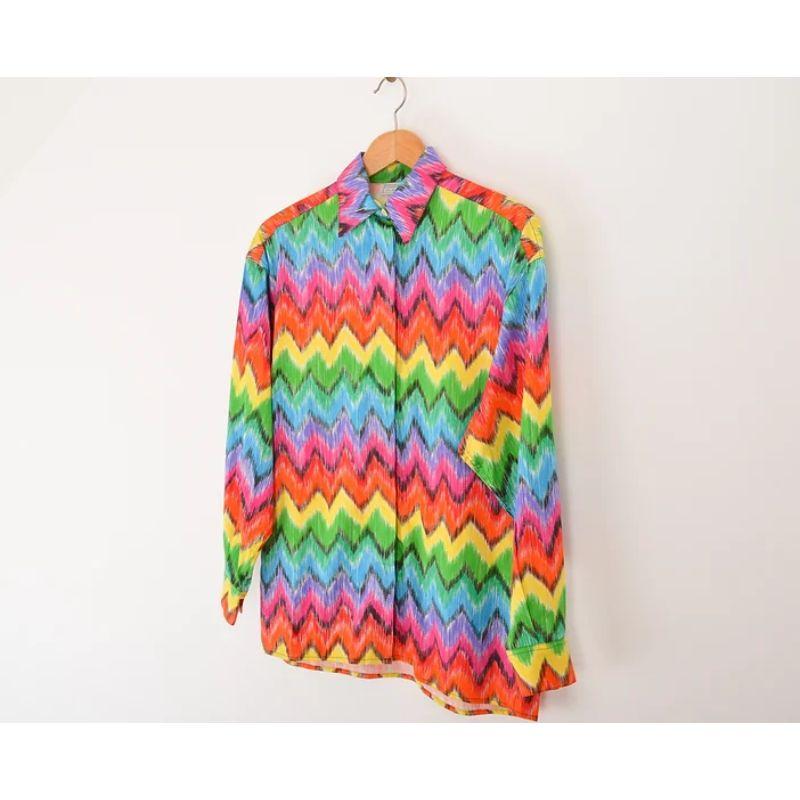 1990's Versus by Gianni Versace Rainbow Zig Zag shirt.  

Features:
Central line button fasten
Vibrant print
Long sleeves
100% Cotton
Sizing: Pit to Pit: 20''
Pit to Cuff: 20''
Nape to Hem: 30''
Recommended Size: Small - Medium
Condition 10/10