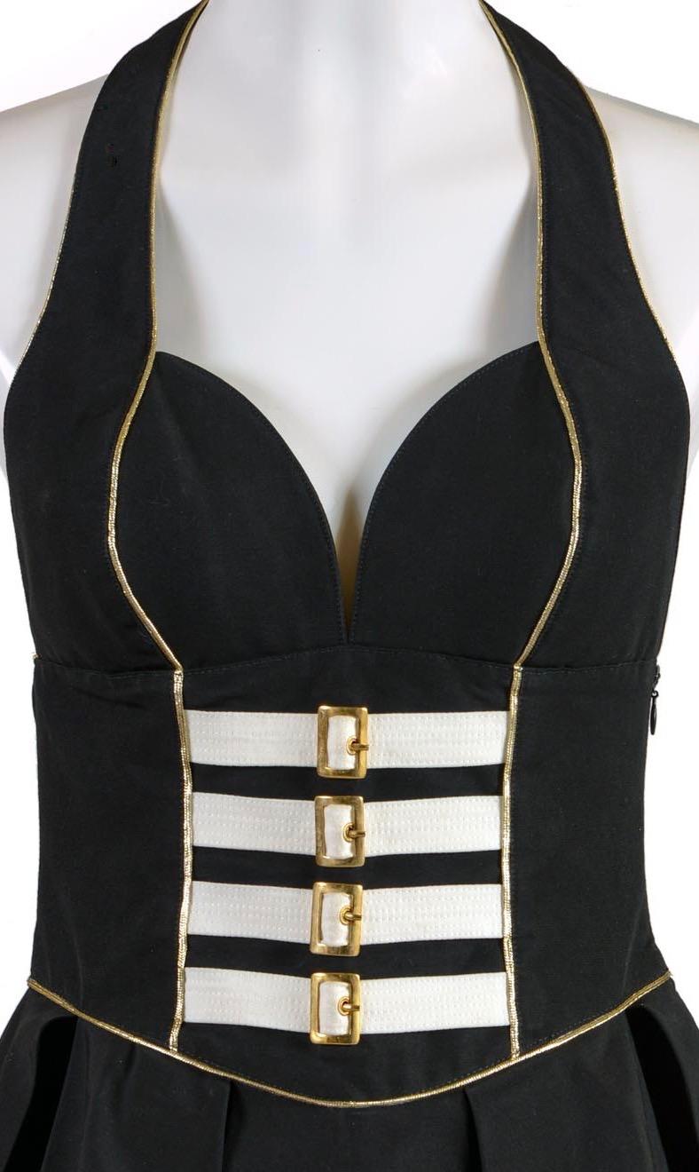GIANNI VERSACE - VERSUS Spring / summer 1993 collection
Black mini dress with tulle underskirt, finished with golden trimmings and small golden metal buckles in the corset
100% ottoman cotton 
100% viscose lining
Size IT 42
Made in Italy
Flat