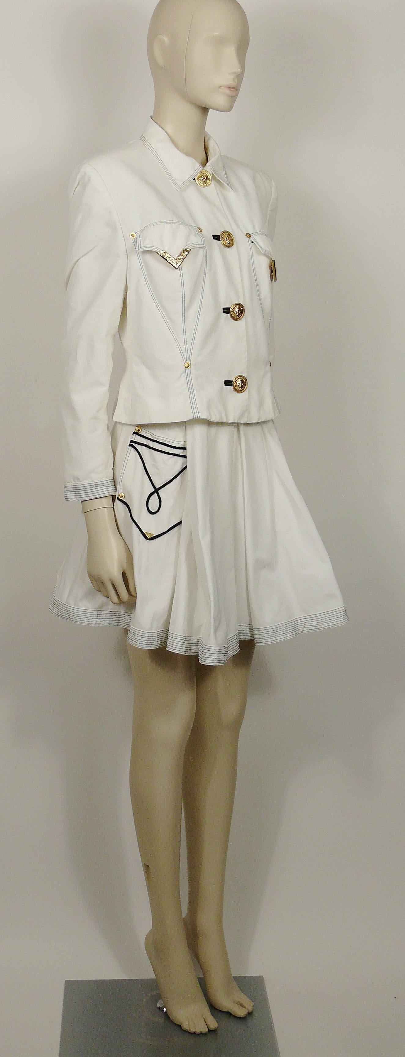GIANNI VERSACE VERSUS vintage 1990s white jacket and skirt ensemble featuring Western details.

The jacket features :
- White cotton with black stitching details.
- Long sleeves.
- Shoulder pads.
- Classic collar.
- Oversized lion head button down