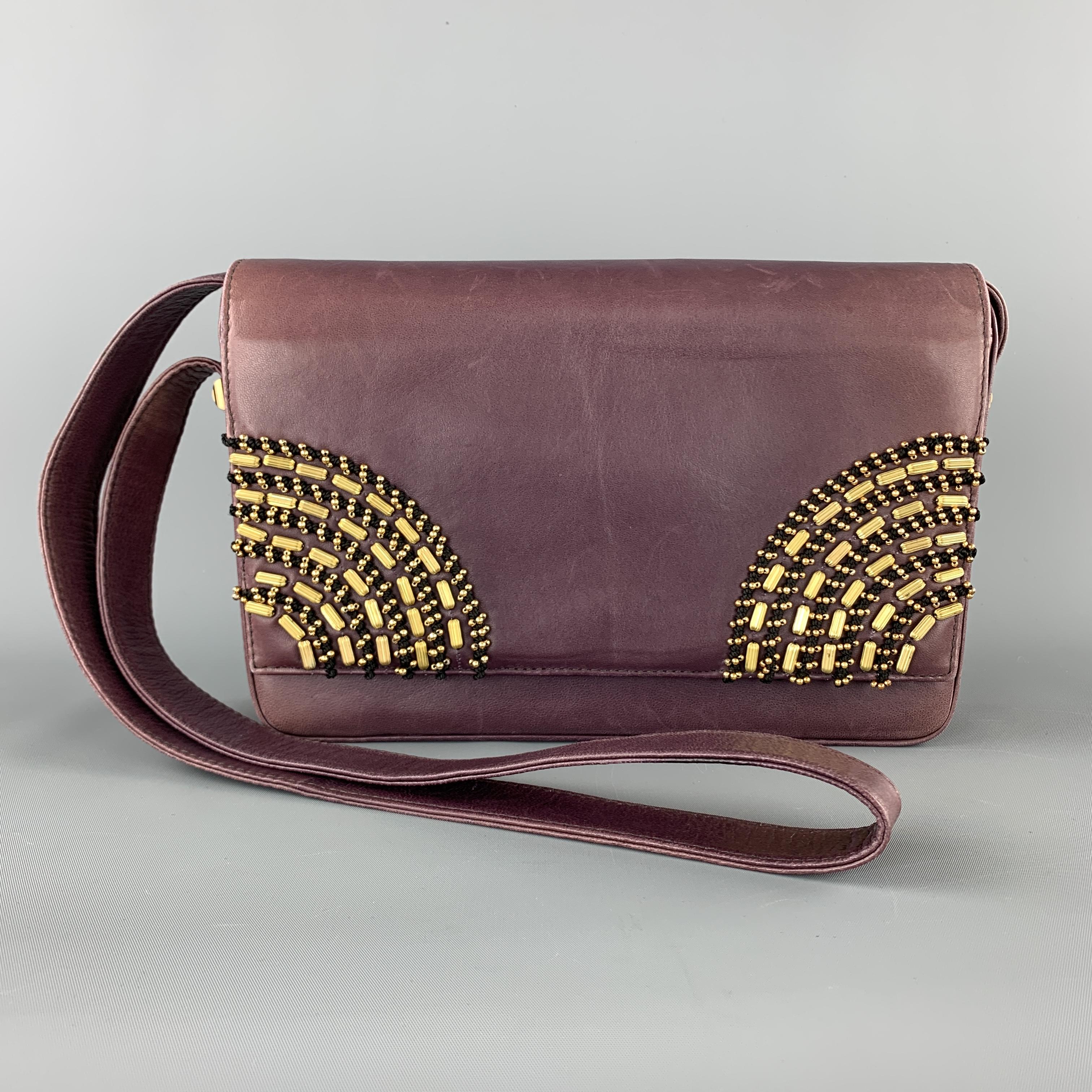 Vintage 1980's GIANNI VERSACE COUTURE shoulder bag comes in plum purple leather with a snap closure top flap detailed with black embroidery and fol tone metal beadwork. Discolorations and fading throughout leather. As-is. Made in Italy

Good