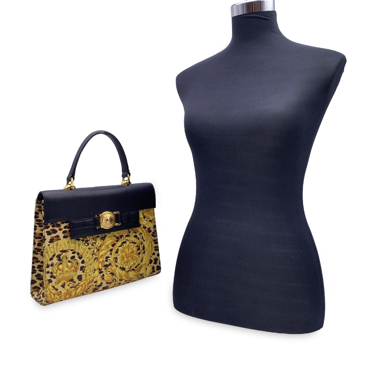 Beautiful vintage rare Gianni Versace handbag with iconic Baroque Wild Flower print. Printed canvas with black leather detail and handle. Flap with magnetic button closure. Gold metal hardware. Rear zip pocket. Gold tone canvas lining. 1 side zip