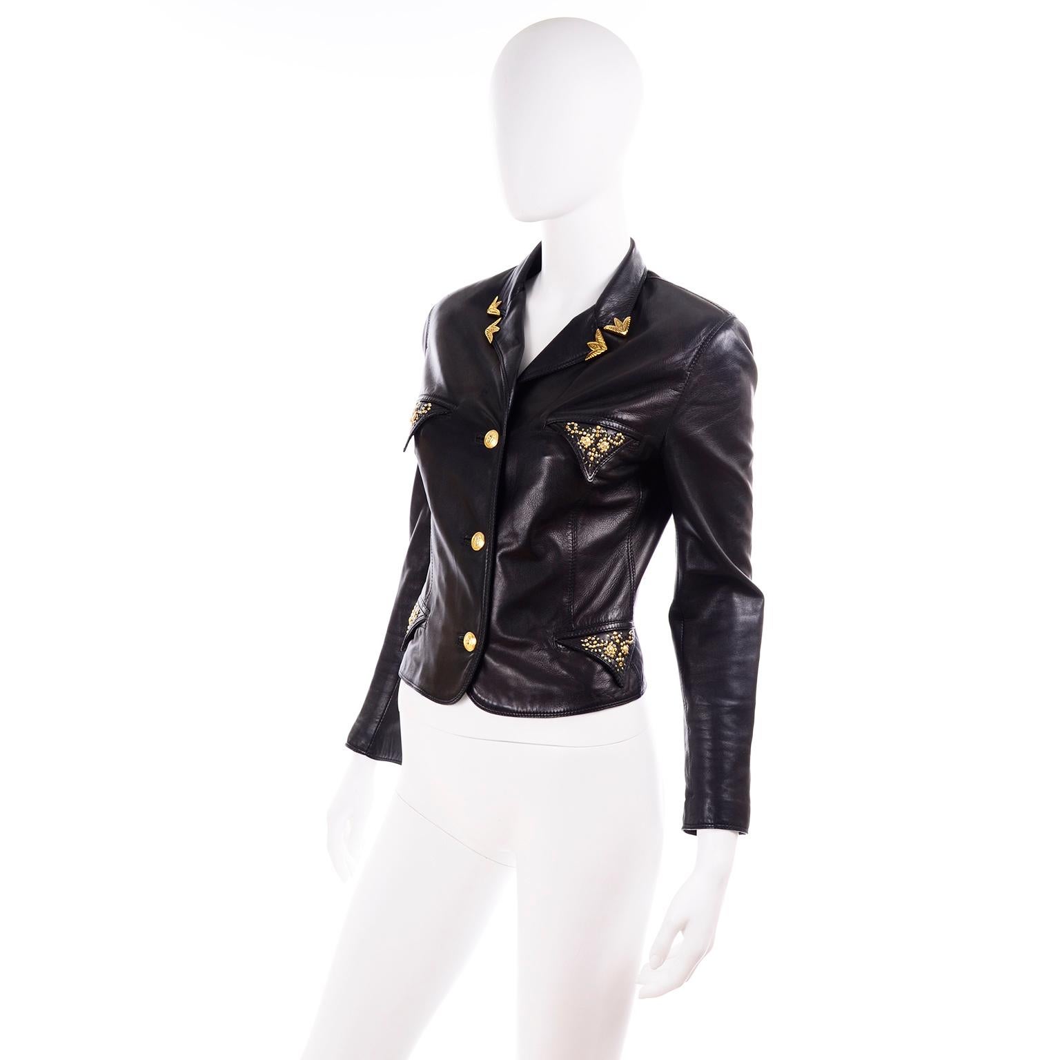 This vintage moto jacket was designed by Gianni Versace in the 1990's and features his signature leather elements including gold tone western style collar tips and studs. The jacket is a soft black lambskin leather and is fully lined. There are gold