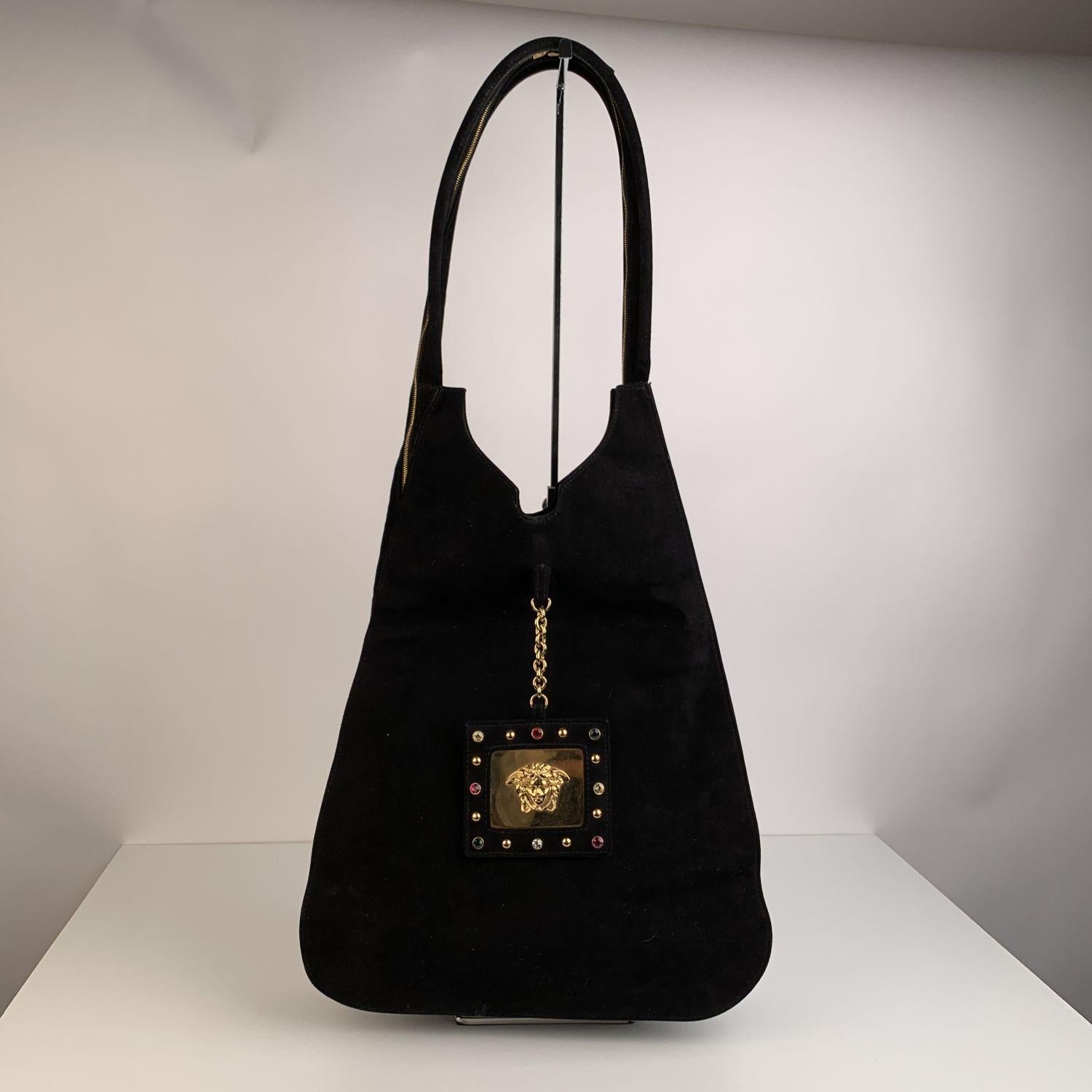 This bag was authenticated by REAL AUTHENTICATION.

Gianni Versace Vintage black suede hobo bag with multicolored rhinestones detailing. Double wrap-around zipper closure (the closure is located along the entire length of the shoulder straps). 2