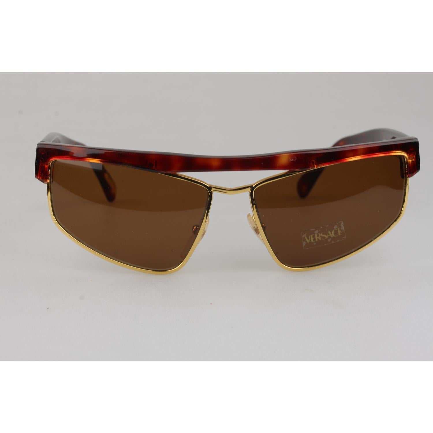 Tortoise brown, cat-eye rectangular shaped vintage sunglasses by Gianni Versace. From the 1980s, with gold metal accents and Gianni Versace 100% Total UVA UVB protection original lenses (sticker / label attached).
MATERIAL: Acetate

COLOR: