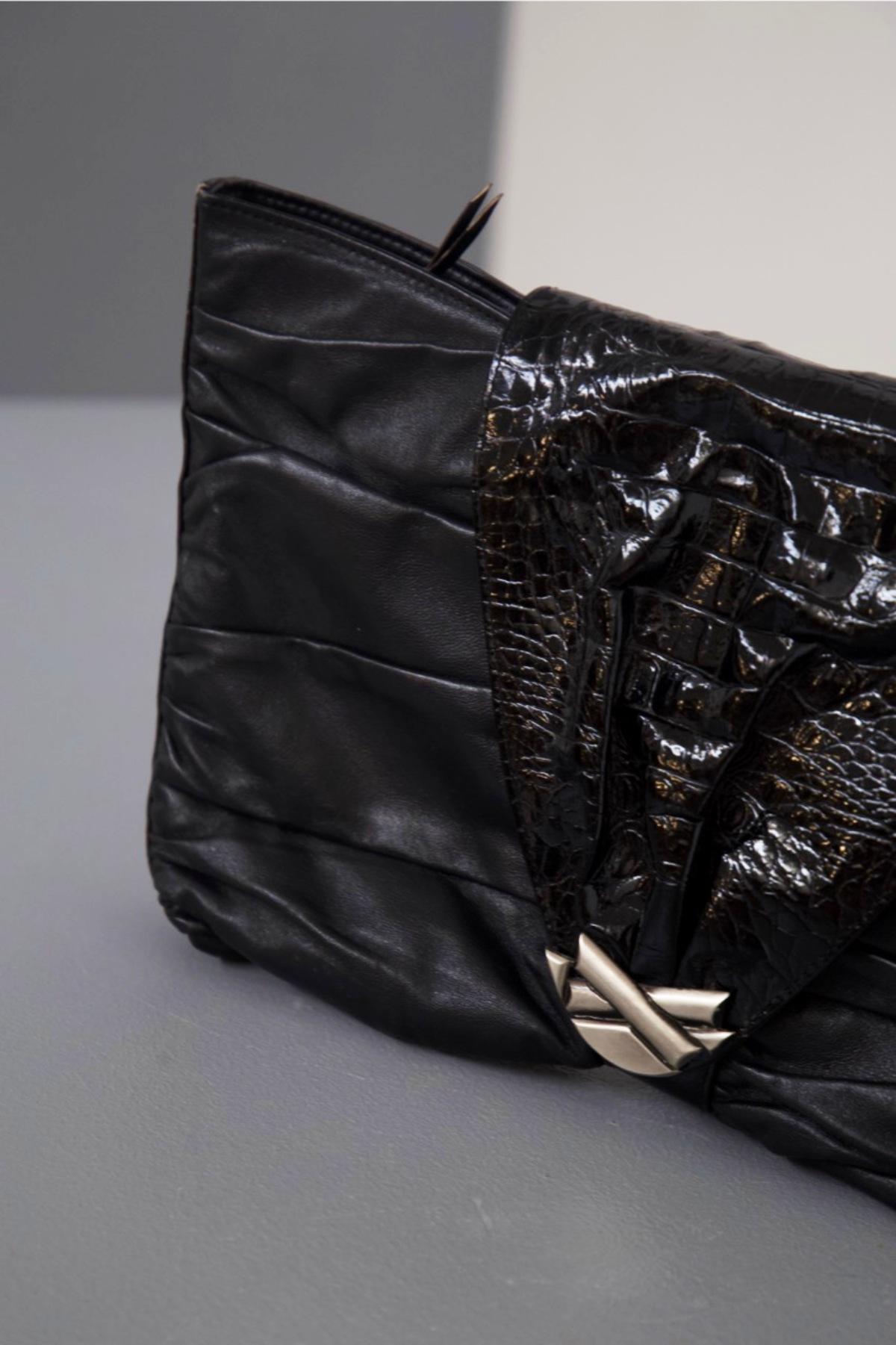 Elegante schwarze Leder-Clutch-Tasche, entworfen von Gianni Versace in den 1980er Jahren, feine italienische Handwerkskunst.
ORIGINALETIKETT UND -MARKE.
Die Tasche hat eine klassische, abgeschrägte, rechteckige Form, mit sehr weichen Linien aufgrund