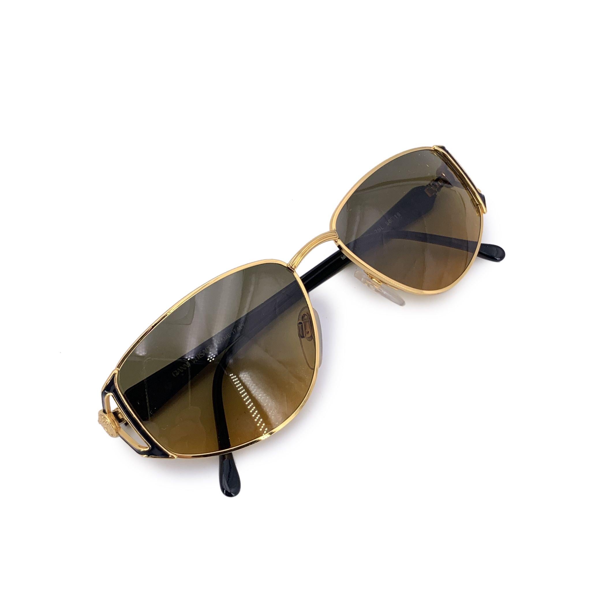 Discover the timeless allure of Gianni Versace vintage sunglasses, designed to capture the bold glamour of the 1980s. These gold and brown aviator-style sunglasses embody the classic elegance and luxury that the Versace brand is known for. The warm