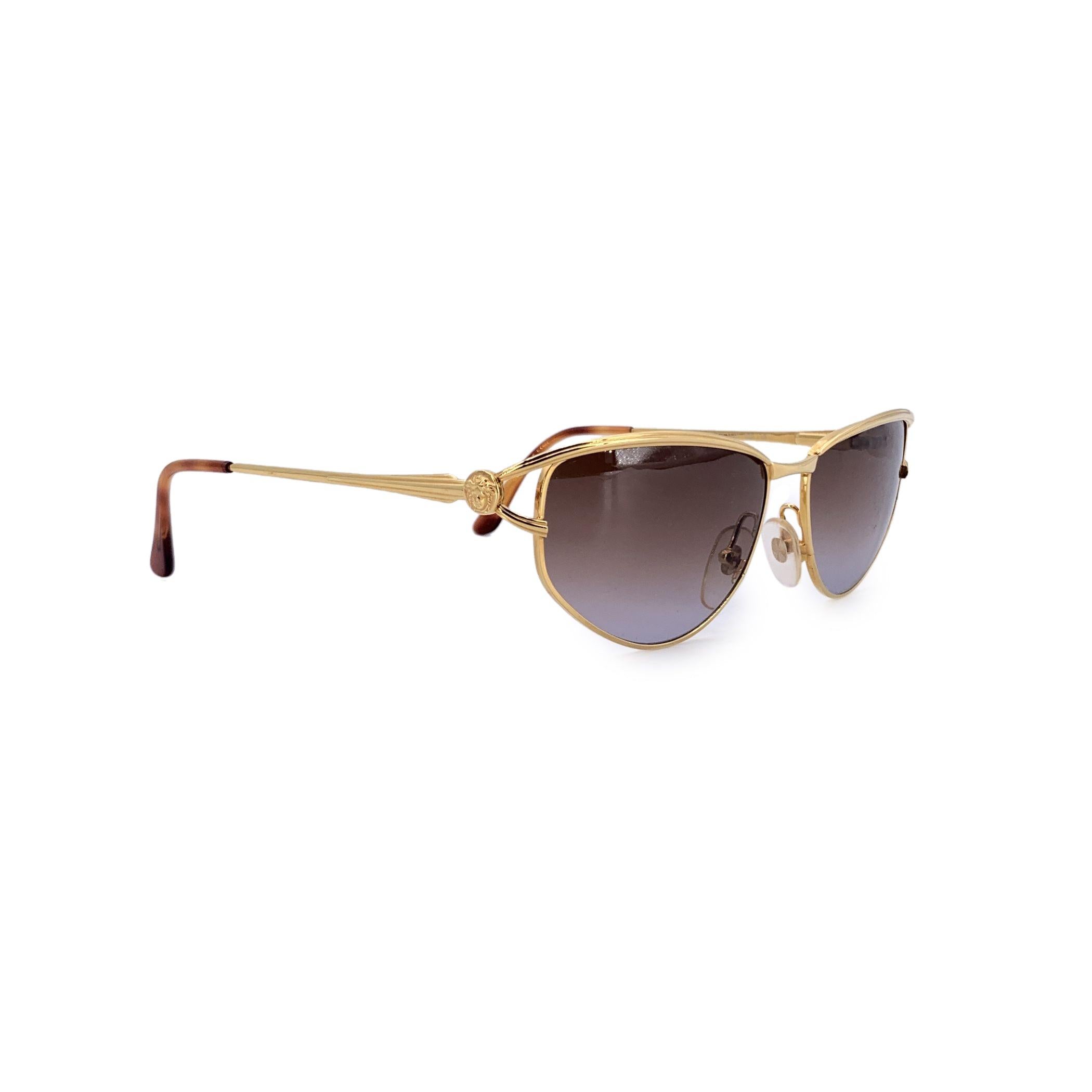 Step into the world of iconic luxury with these Gianni Versace vintage gold sunglasses. With a striking gold-colored frame, they exude a sense of refined sophistication that only Versace can deliver. The oval-shaped lenses provide a flattering and