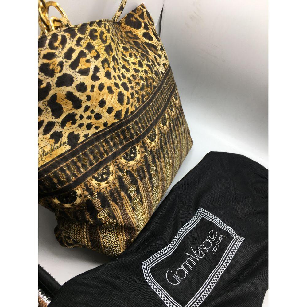 Gianni Versace Vintage Leather Handbag in Multicolour

Gianni Versace X Christian Fishbache bag. Crafted in spotted fabric. Leather interior and golden chains. 
Measures 31 cm high, 40 cm long, 10 cm deep, 30 cm handle.  New with tag. Never used.