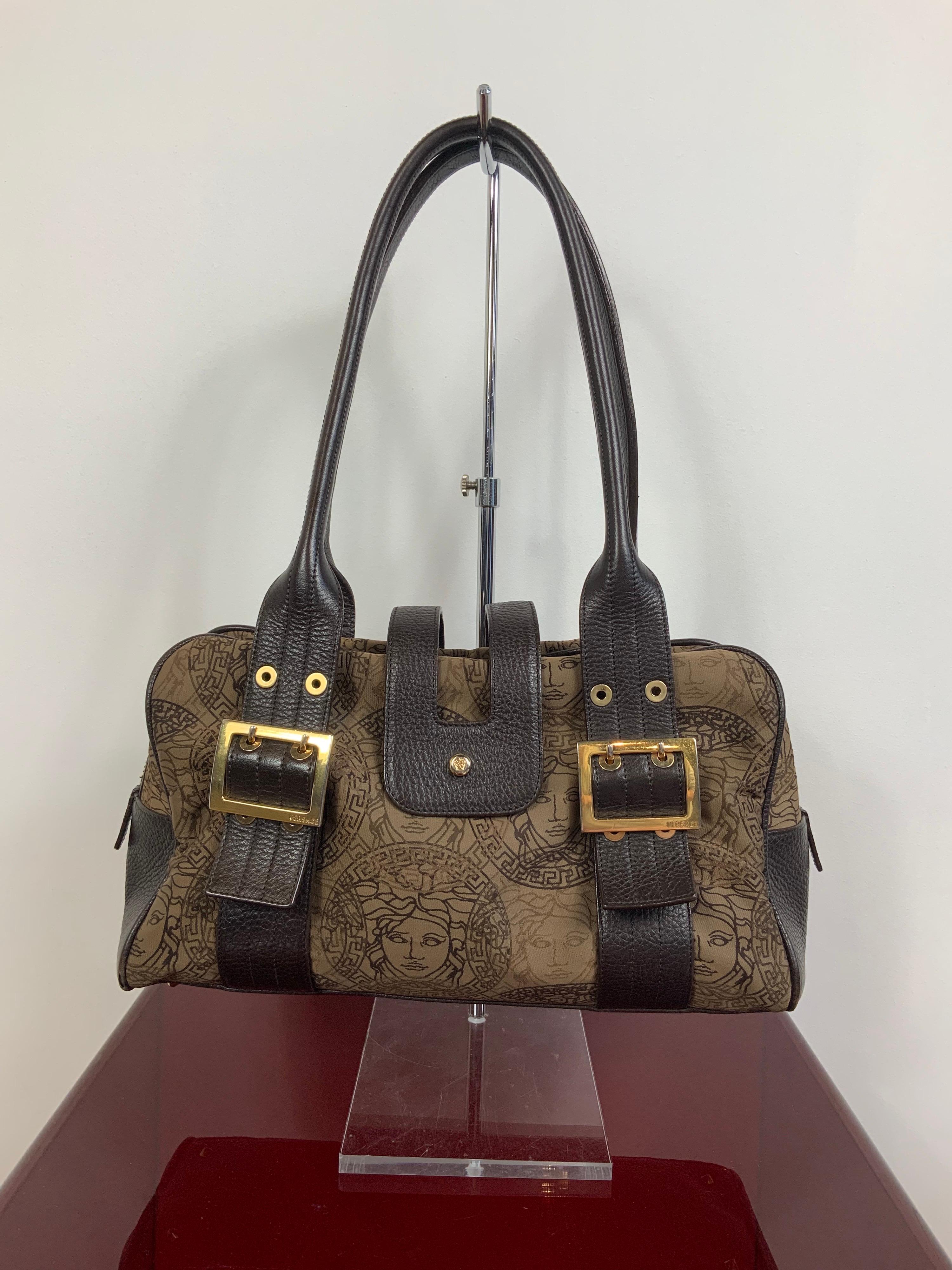 Gianni Versace medusa bag. About 90s.
Featuring medusa pattern fabrics, leather handle and details and gold hardware (the gold color is a little bit ruined). Zip and clip closure.
Bag interior is lined by a brown fabric. 
Bag corners show some sign