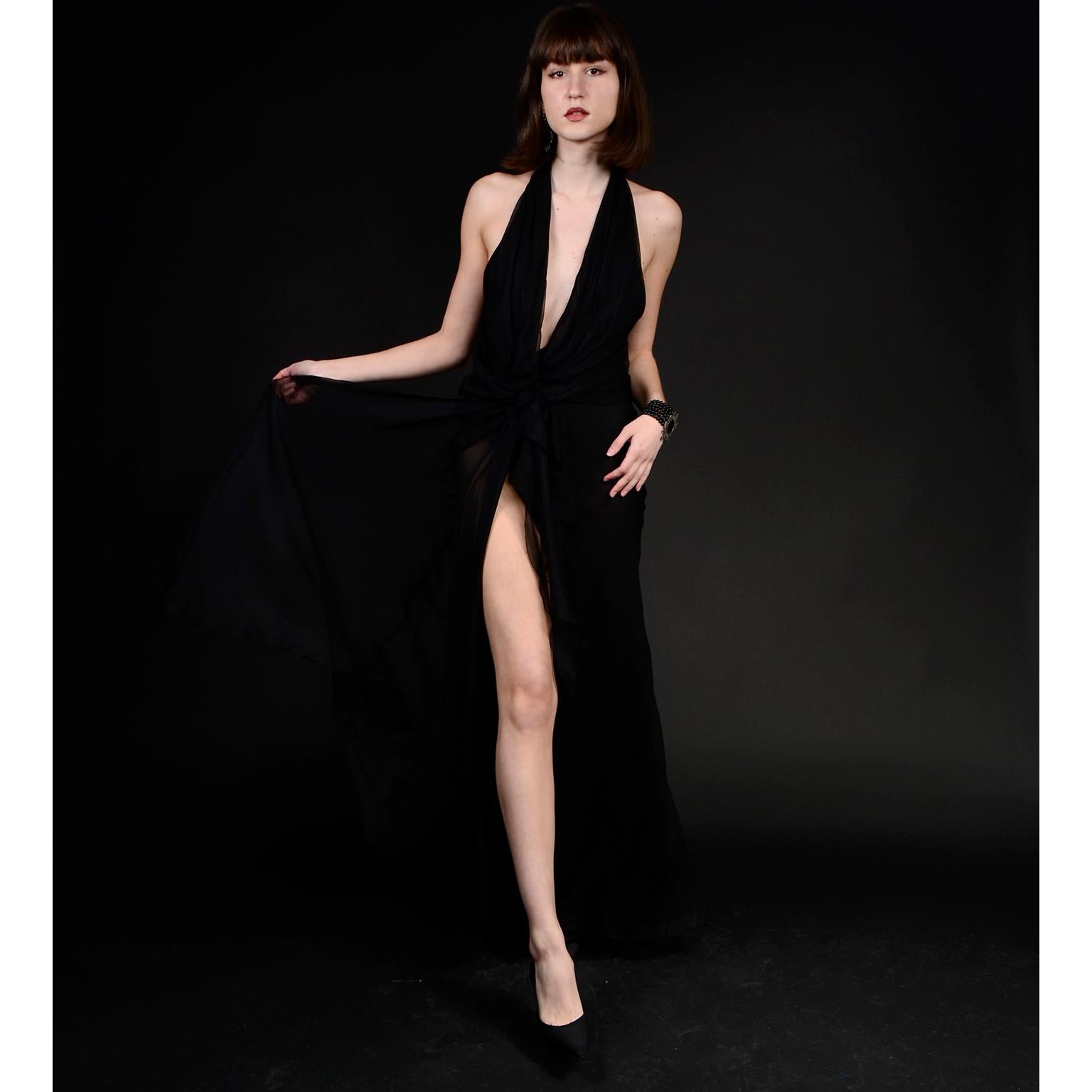 This is an absolutely stunning vintage Gianni Versace Couture evening dress. This vintage black silk chiffon dress has a thigh high cut slit in the front that reveals a leg, and a deep plunging neckline. We especially love the gorgeous sheer panel