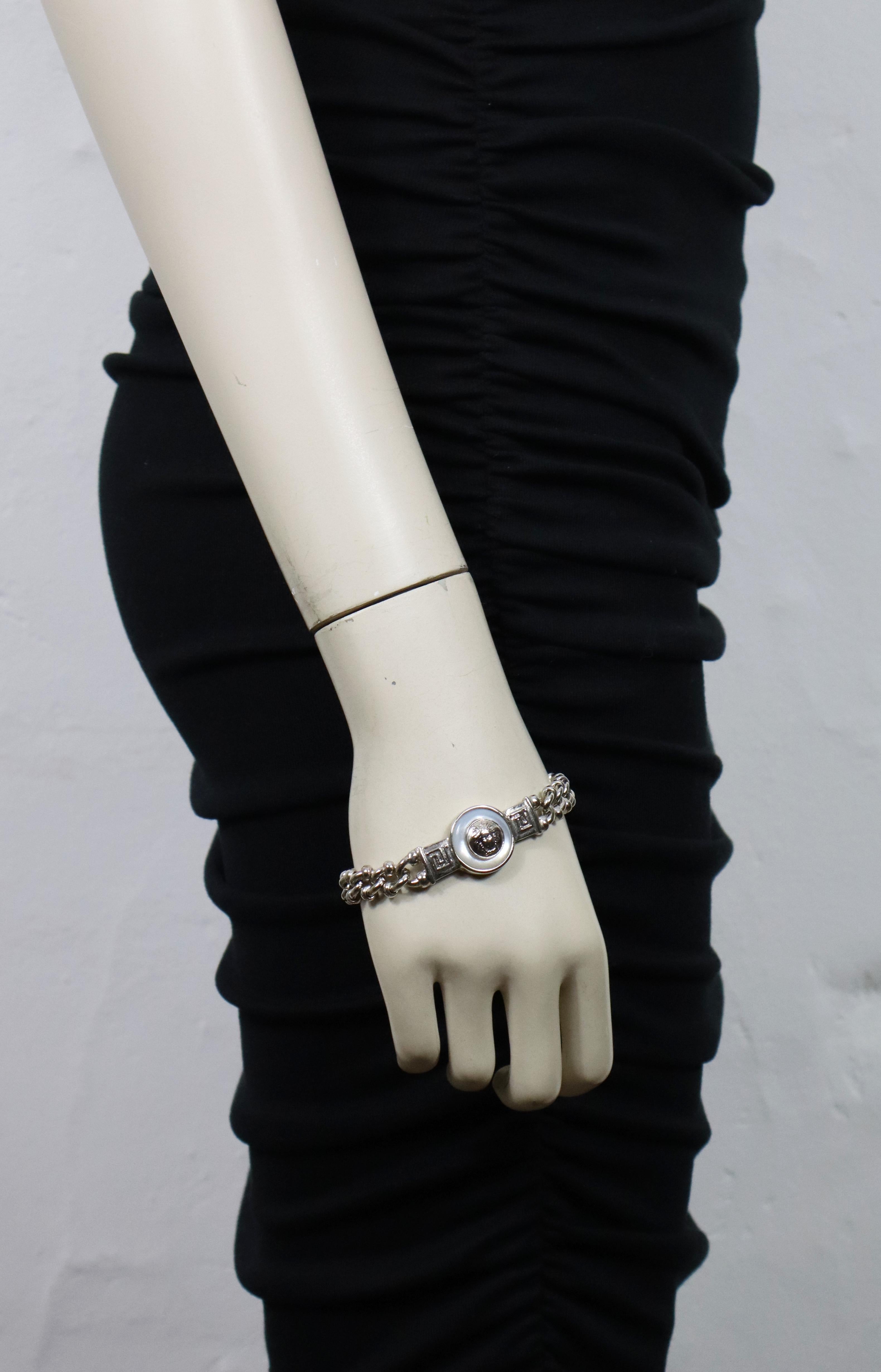 GIANNI VERSACE vintage silver tone chain bracelet featuring a Medusa medallion on an iridescent resin disc at the center.

Toggle clasp.

Embossed GIANNI VERSACE Made in Italy.

Indicative measurements : length approx. 19.5 cm (7.68 inches) / width