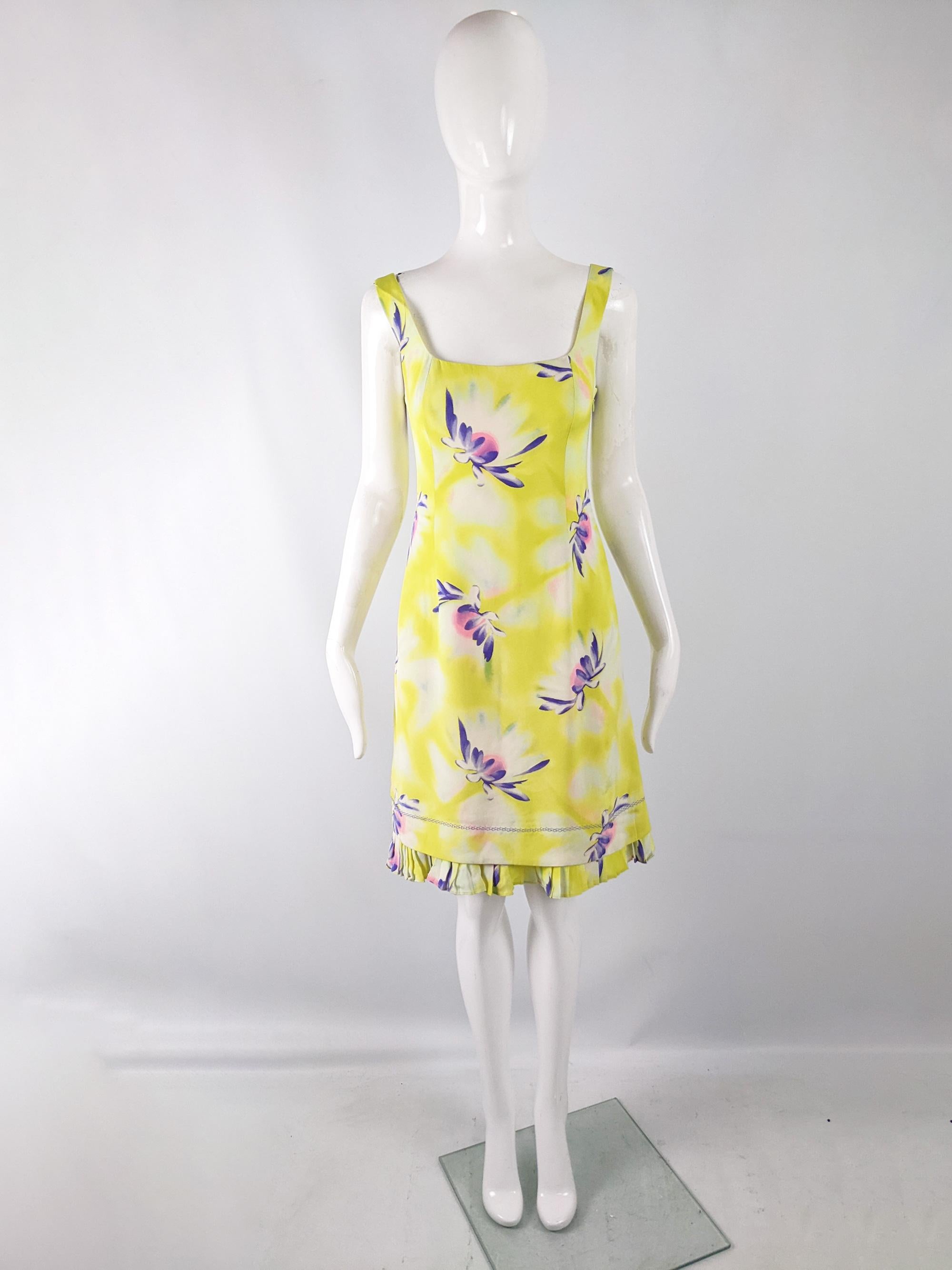 A fabulous vintage womens dress from the 90s (most likely the Spring 1996 collection) by luxury Italian fashion designer, Gianni Versace for the Gianni Versace Couture label. In a yellow silk with a bold purple, white and pink floral pattern