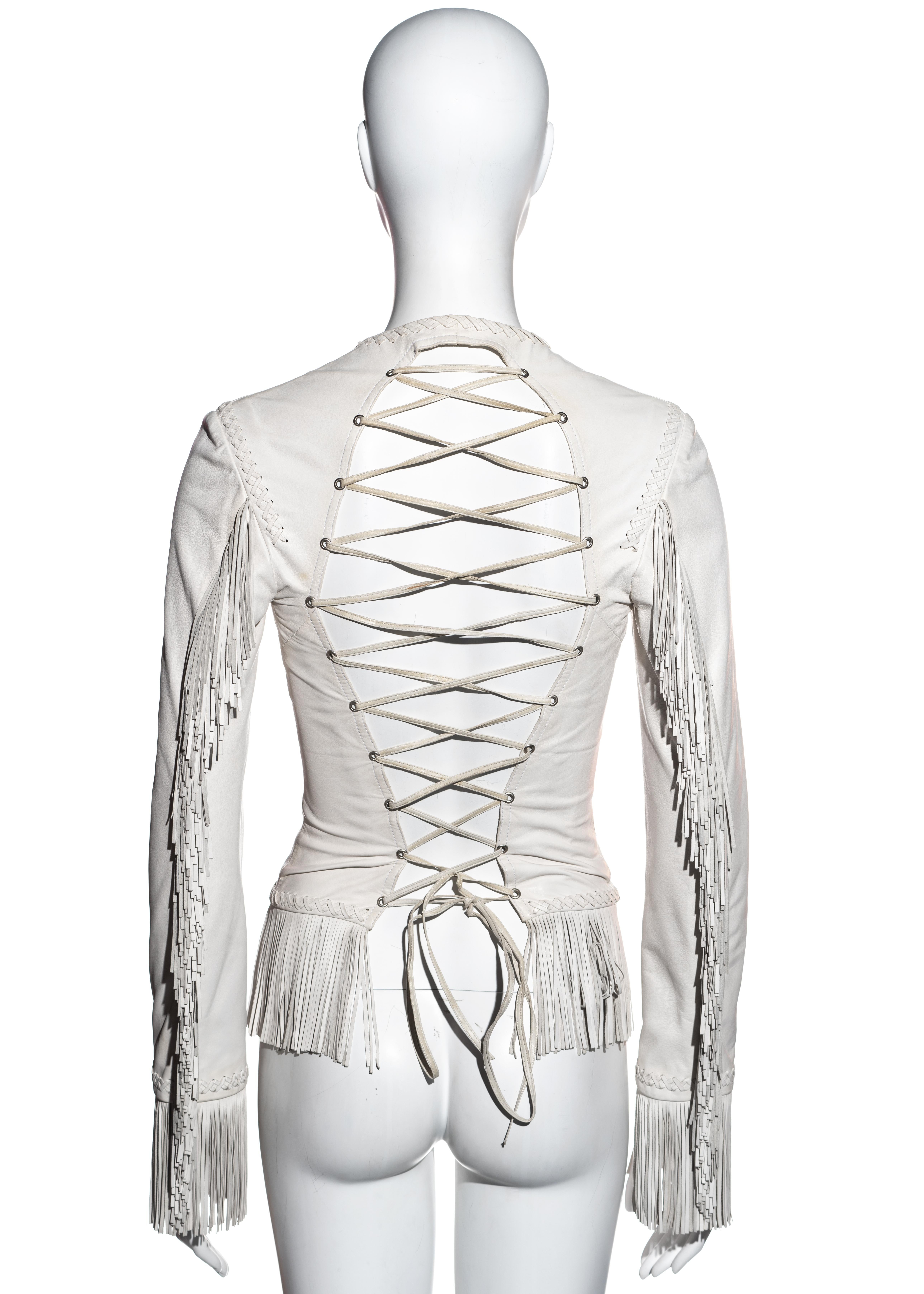 ▪ Gianni Versace white leather jacket 
▪ Open back with leather lace-up fastening 
▪ Leather fringes on sleeves, cuffs and waist 
▪ Braided leather detail on seams 
▪ Zip front fastening 
▪ IT 42 - FR 38 - UK 10 - US 6
▪ Spring-Summer 2002