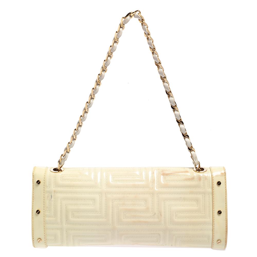 This Versace bag is a beautifully sewn creation that is made to last. The white-hued quilted patent leather shoulder bag comes in a flap style with a plaque detailing on the front. It opens to a satin-lined interior and is held by a shoulder