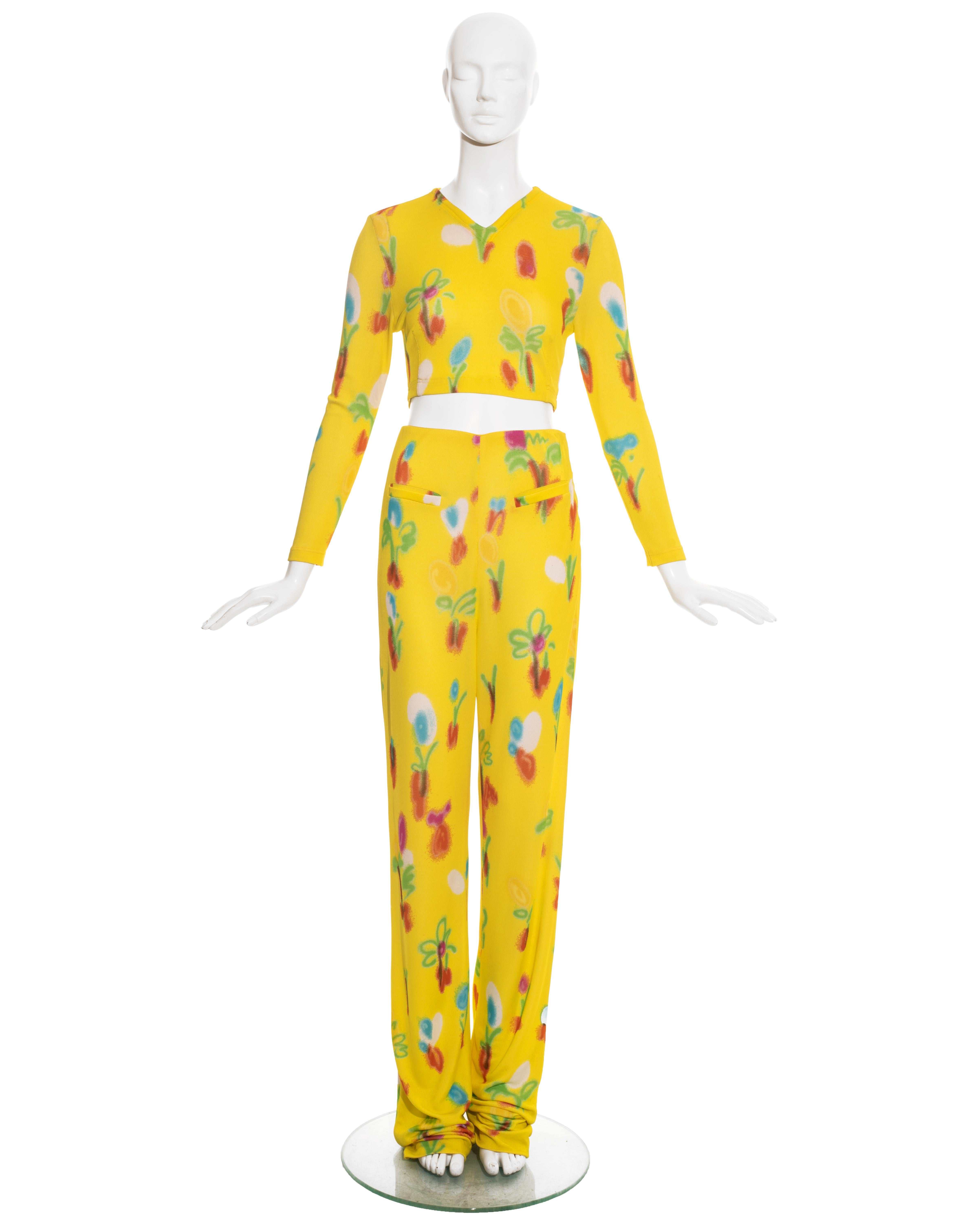 Gianni Versace yellow jersey pant suit with multicoloured graffiti floral print: fitted v-neck long sleeve sweater and extra long flared pants. Pants can be hemmed to any height. 

Spring-Summer 1996 


