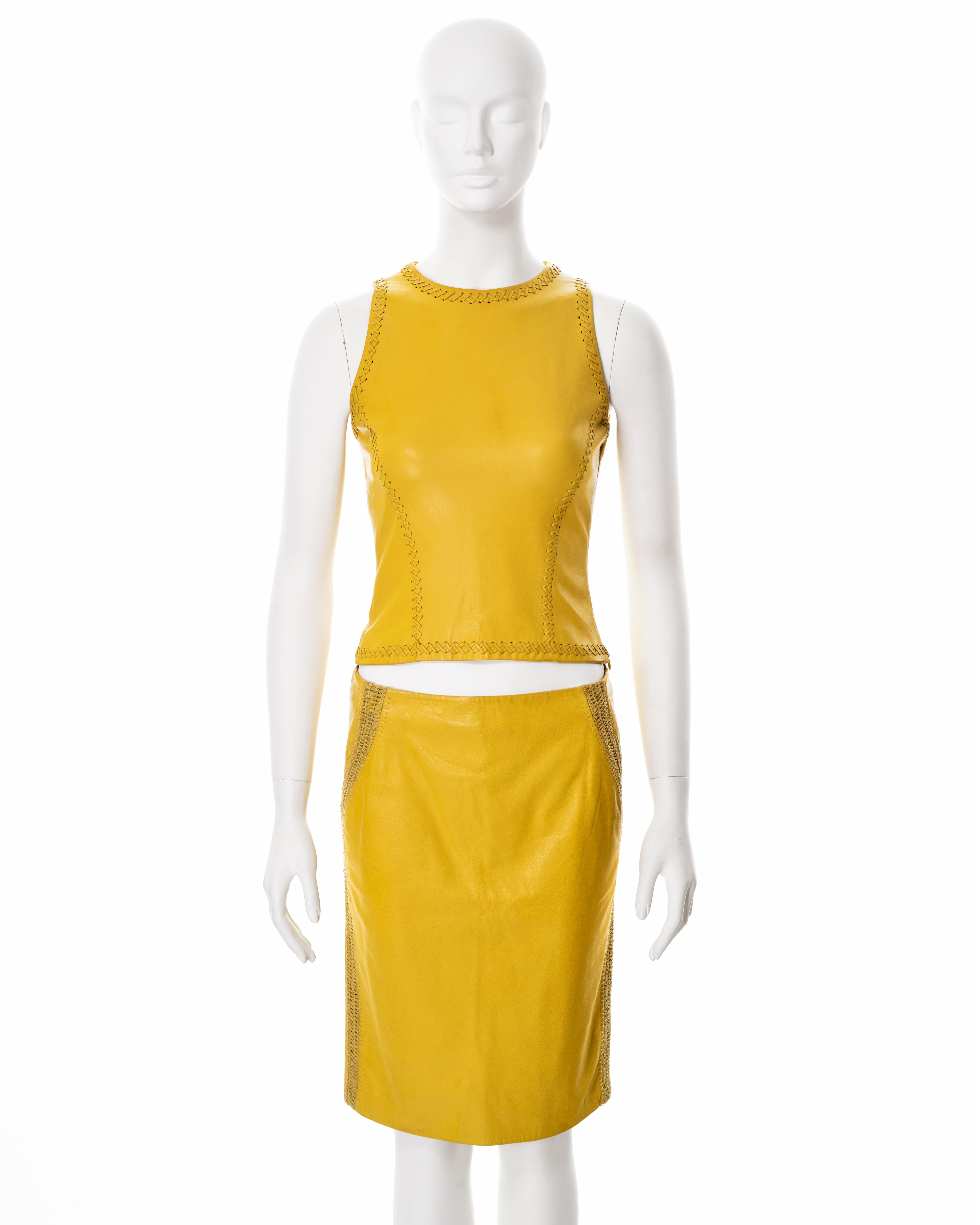 ▪ Gianni Versace leather top and skirt set
▪ Creative Director: Donatella Versace
▪ Sold by One of a Kind Archive
▪ Constructed from yellow lambskin leather 
▪ Fitted leather top with open back and lace-up fastening 
▪ Low-rise pencil skirt with