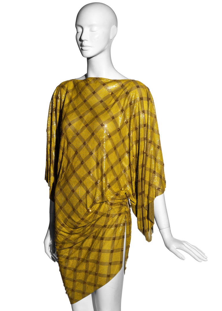 ▪ Gianni Versace Yellow checkered Oroton chainmail evening mini dress
▪ 100% Aluminium, 100% Silk 
▪ Amber crystal embellishments 
▪ Ruched side seam with leg slit 
▪ Built-in waist belt
▪ Wide sleeves  
▪ Silk trim  
▪ Size Medium 
▪ Fall-Winter