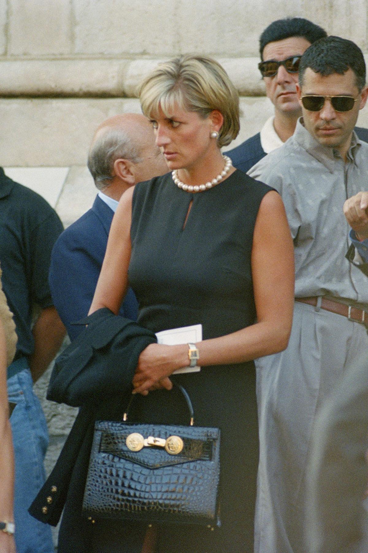 Conçu dans le style 'Kelly' d'Hermès, ce sac vintage de Gianni Versace est composé d'un cuir noir profond qui contraste avec un dos en poils de poney à imprimé zébré et des ferrures dorées. Les fermoirs dorés sur le devant sont ornés des emblèmes de