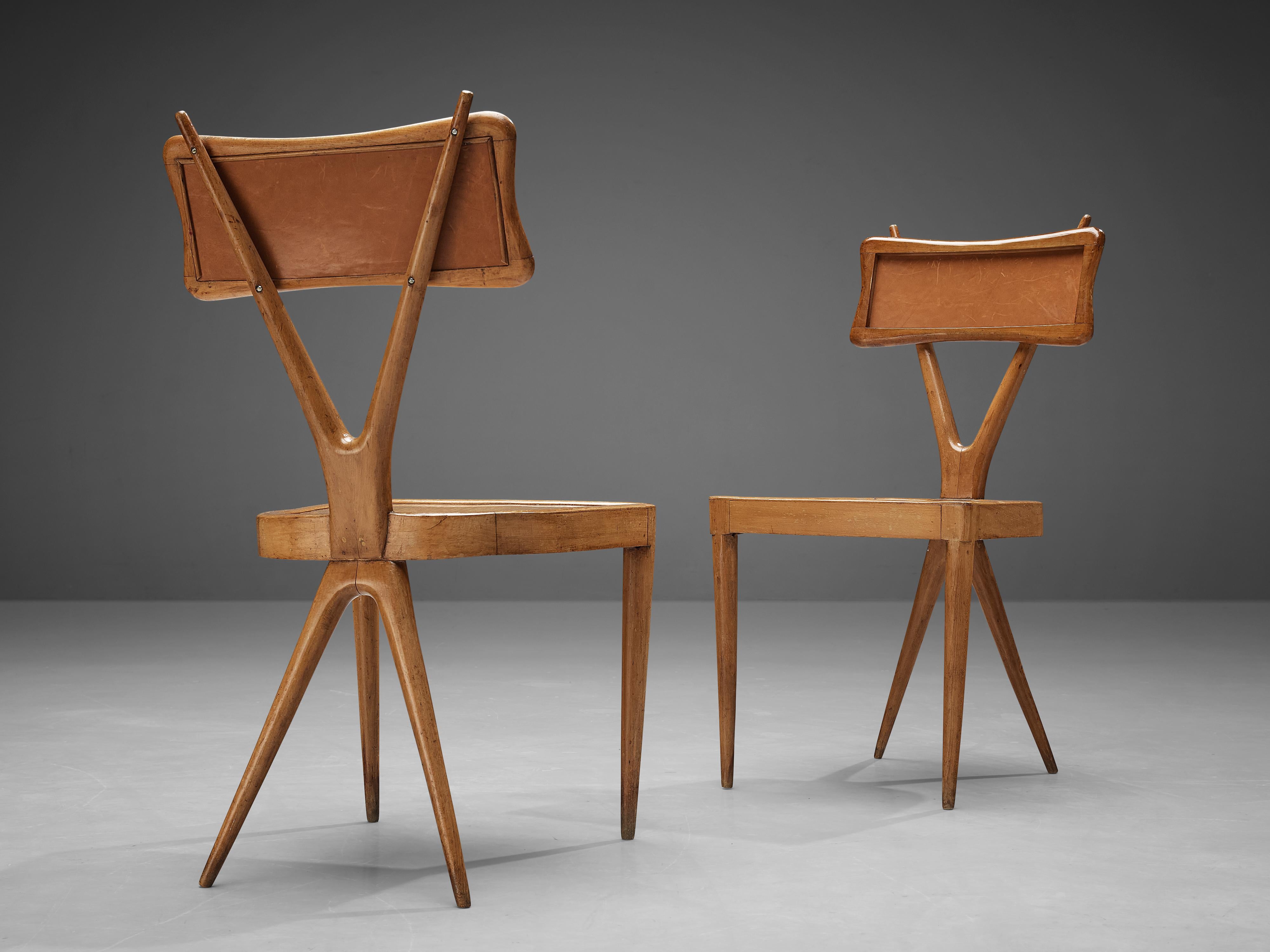Gianni Vigorelli, pair of dining chairs, beech, plywood, leatherette, Italy, 1950s.

These chairs are beautifully constructed featuring a X-shaped frame, a striking detail that convinces visually. The backrest is carved in a subtle manner and