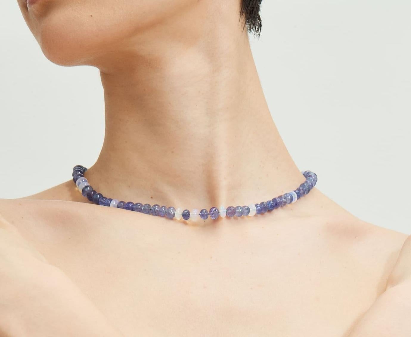 Ajoutez une touche envoûtante à n'importe quelle tenue avec ce collier de perles violet lavande avec des opales Welo et des tanzanites en or jaune 14K. Ce magnifique collier est composé d'opales éthiopiennes scintillantes et de pierres de lune