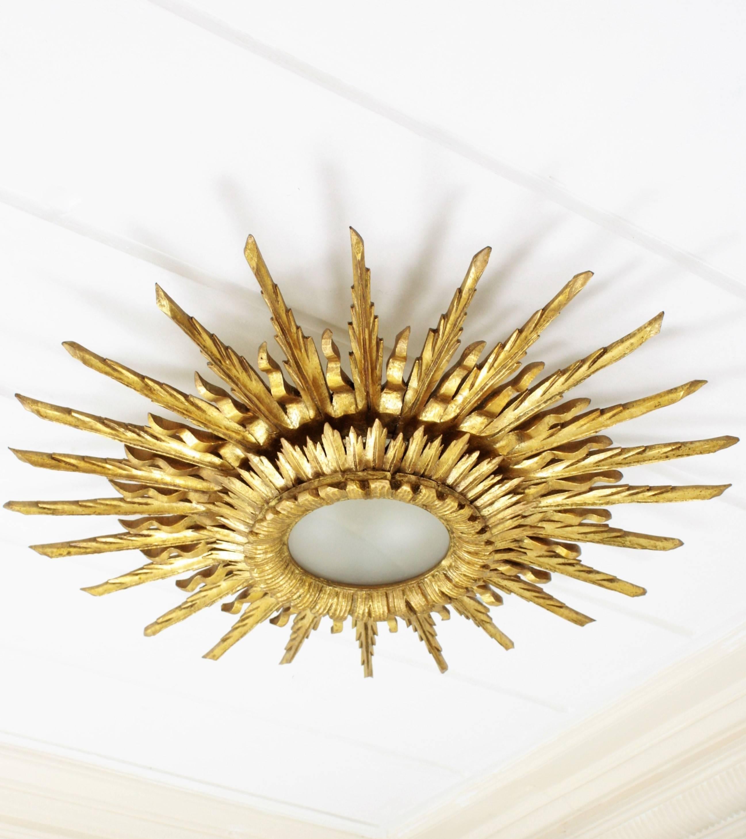 An spectacular giant sized sunburst flush mount or ceiling light fixture in Baroque style made in Spain at the mid-20th century. Large size with two layers of beams in different sizes that make this piece gorgeous and highly decorative even more