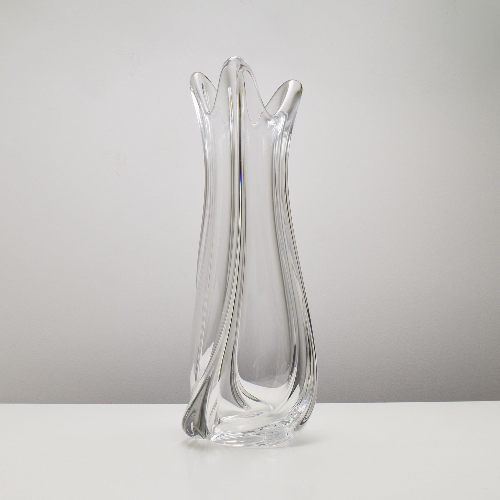Questo eccezionale vaso da terra in cristallo alto 50 cm di Val St. Lambert è una testimonianza dell'arte vetraria belga. La sua forma scultorea è caratterizzata da eleganti curve a spirale, sapientemente realizzate in cristallo soffiato