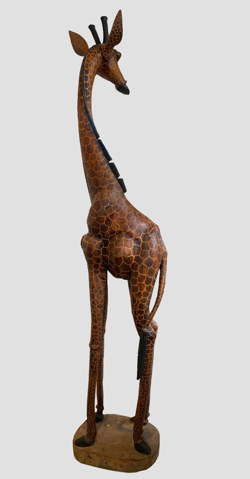This is an amazing piece, hand carved from a single log. The details give a unique character to this giraffe. It was part of a collection originally commissioned by an African big game hunter turned photographer. It has a nice patina and beautiful
