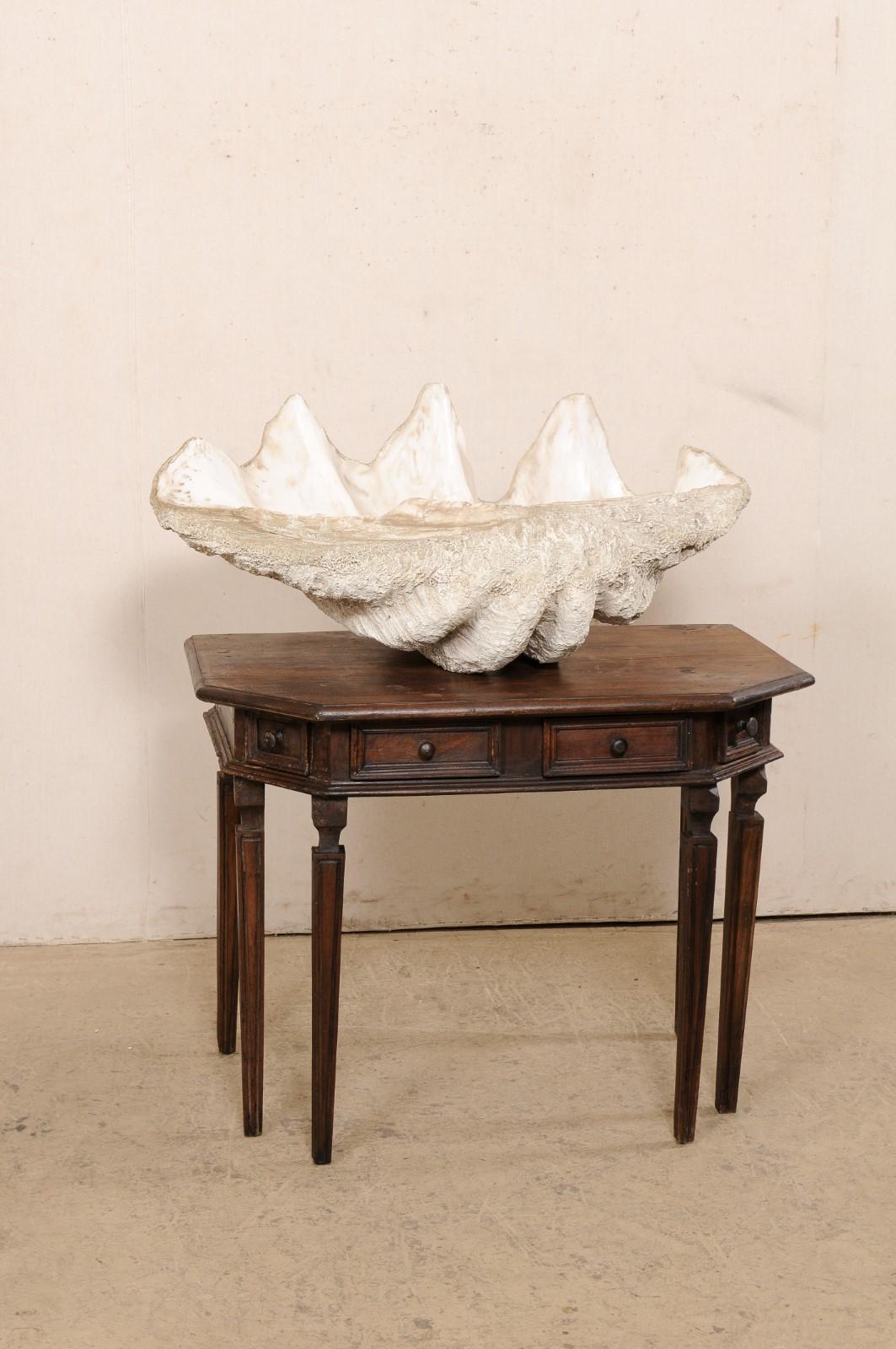 Featuring a giant faux clam shell which looks and feels like the real thing! A replica of Nature's art at its finest; this vintage composite sculpture shell exemplifies fabulous craftsmanship. It has that perfectly bleached-white color (with slight