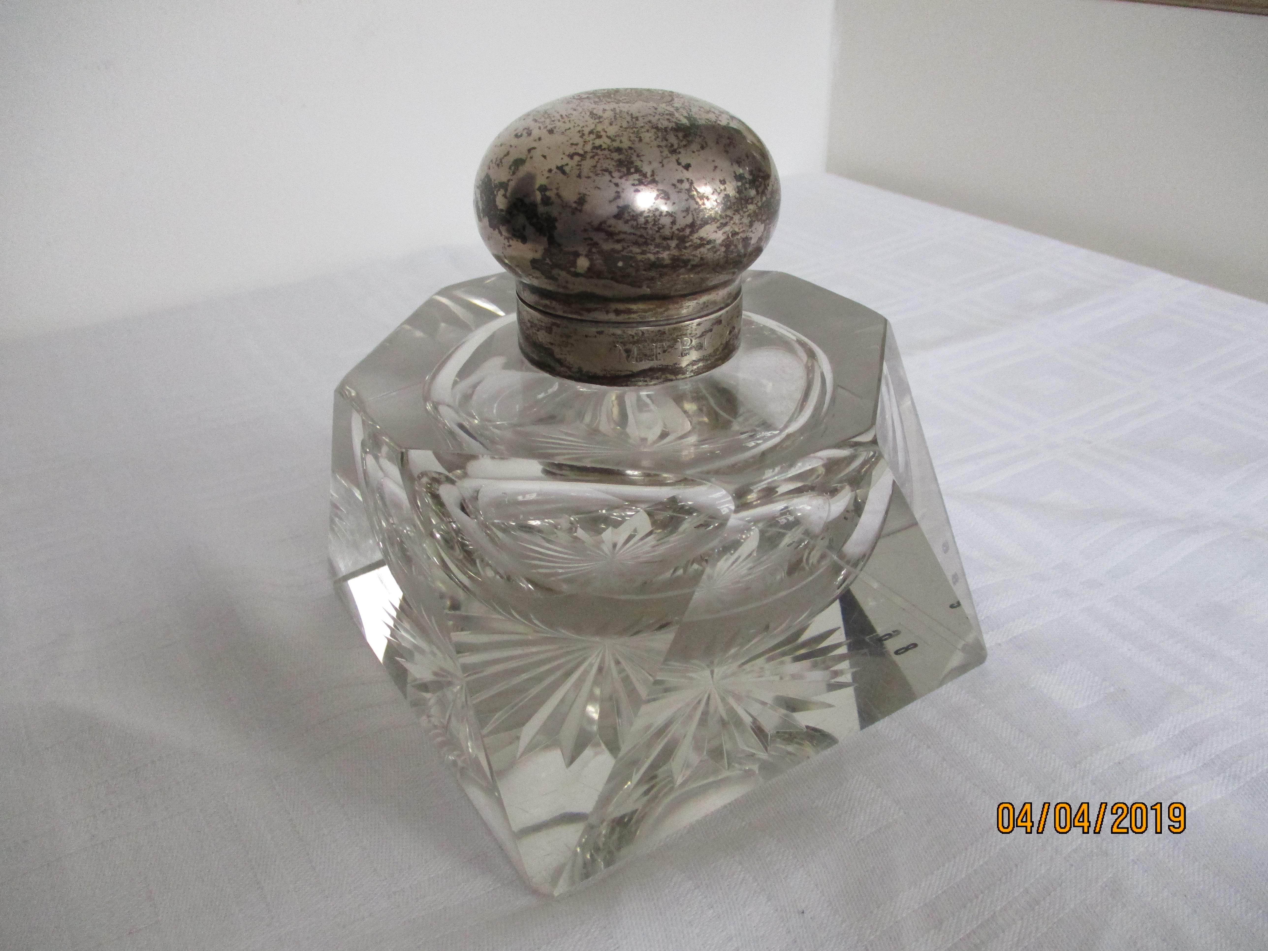 A very nice example of a large glass inkwell with silver marked lid with a hallmark ingraved. To the back of the lid under the hinge are initials and a makers marks. The ingravings are, as far as readable, reading 