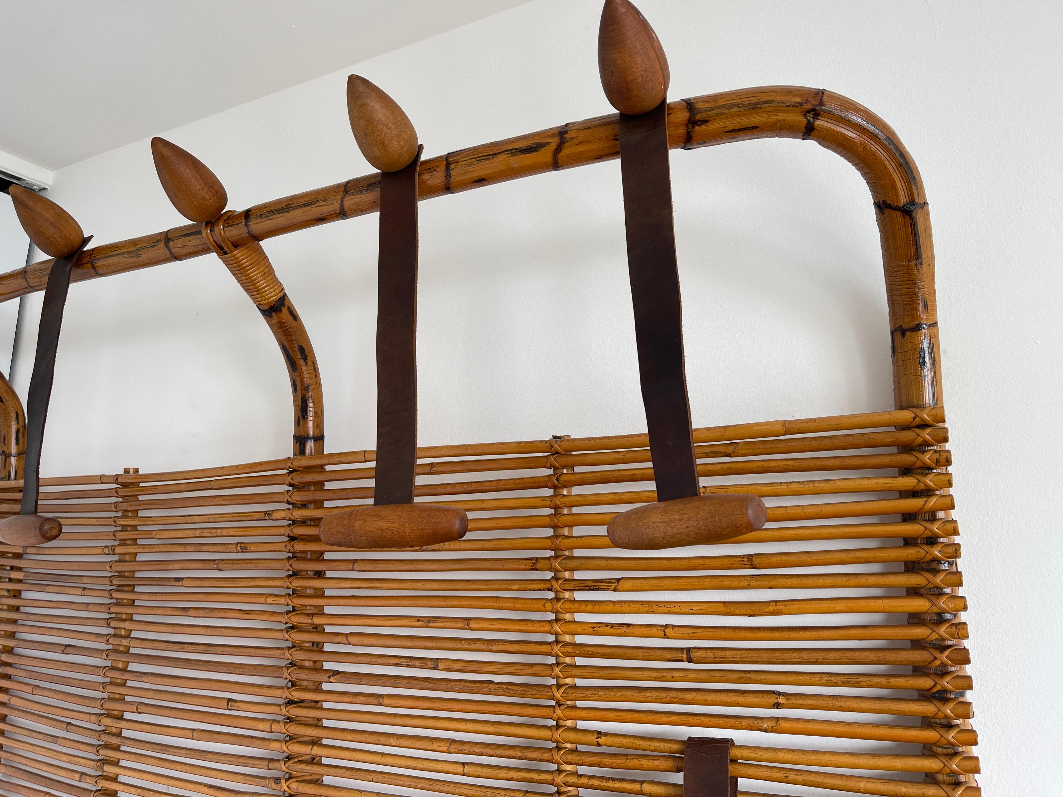 Extremely large scale wall hanging coat rack by Tito Agnoli for Pierantonio Bonacina with floating wood hooks hanging from black leather - a built in floating umbrella holder.
Incredible piece!